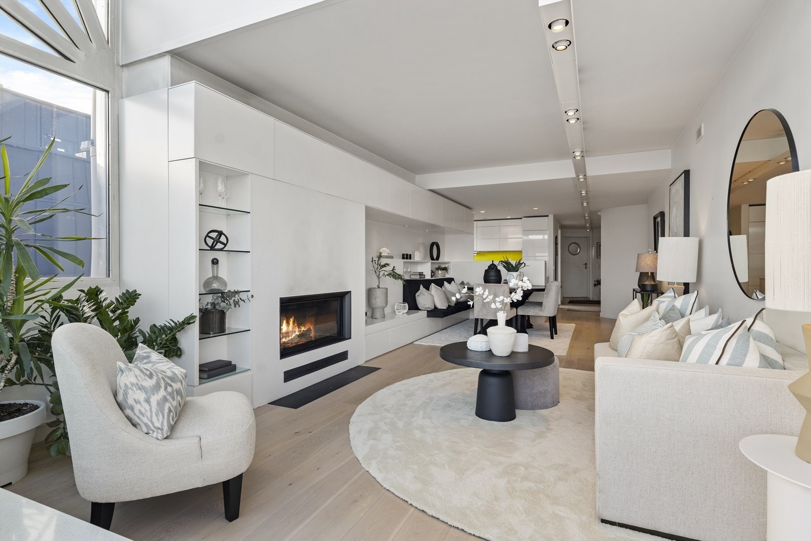 Det er plassbygget hyller og oppbevaring rundt peisen og mot spisestuen. Galleribilde