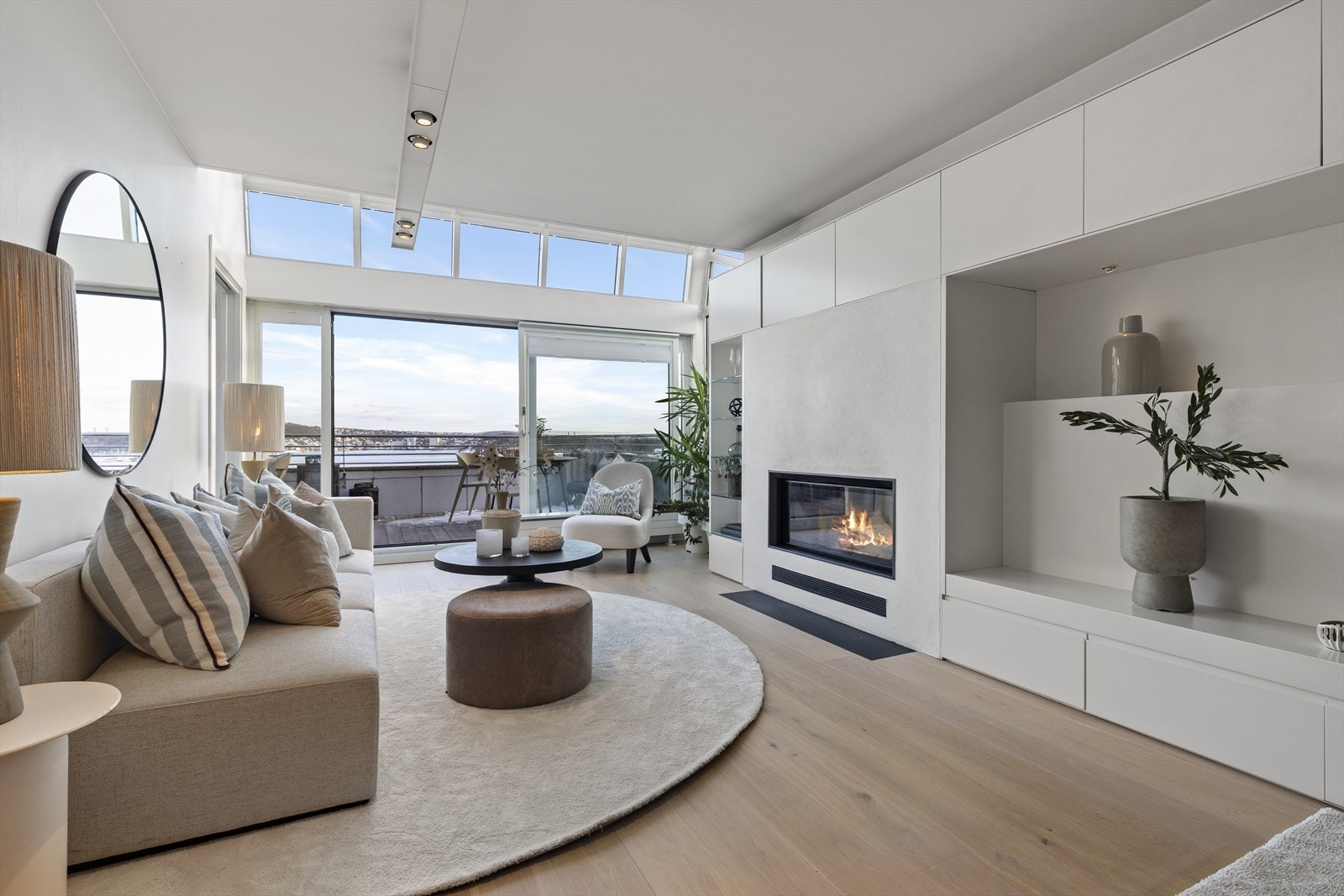 Stuen er svært lys med buede takvinduer og stor skyvedør ut til terrassen. Galleribilde