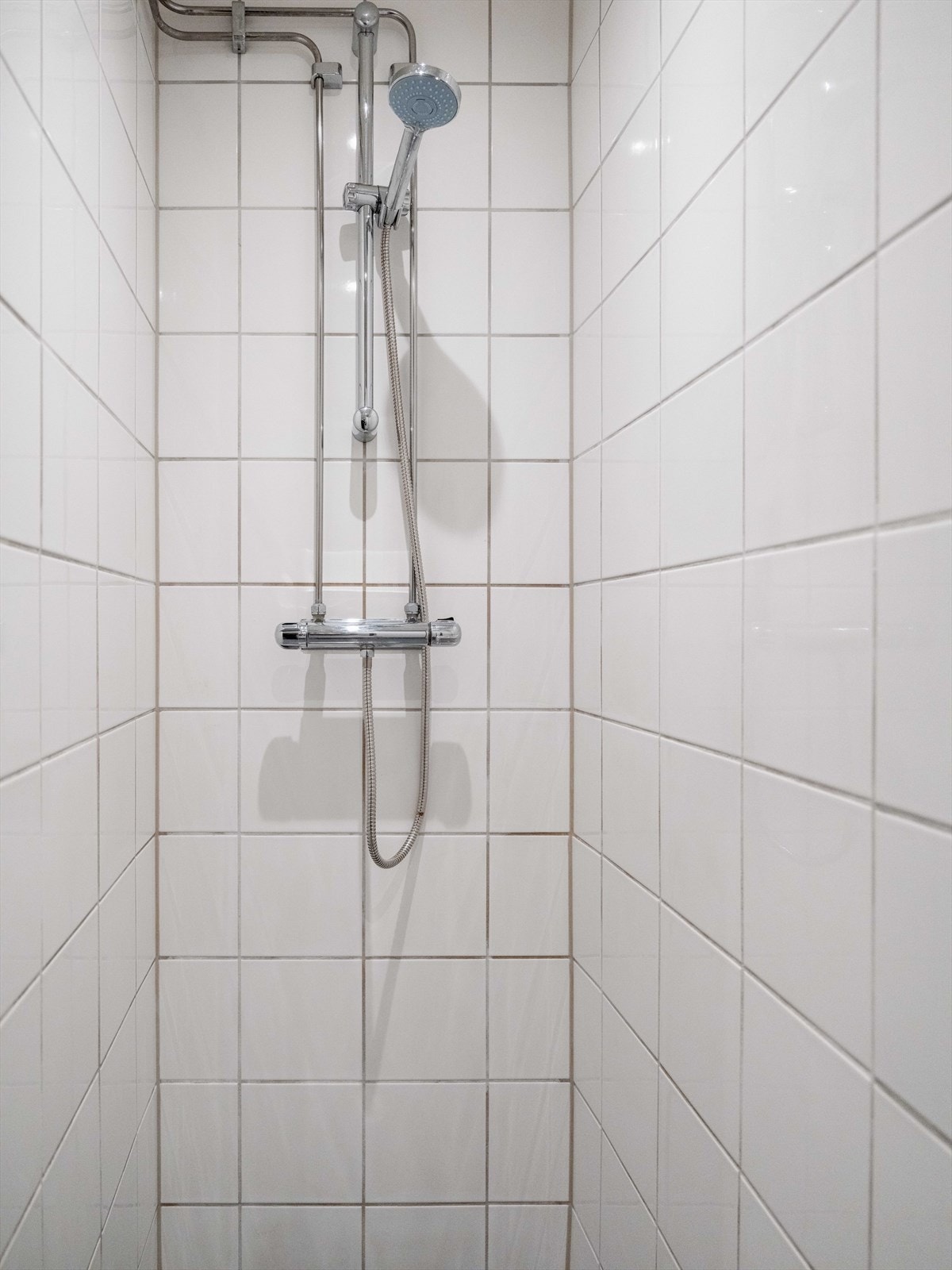 Praktisk dusj på gulv og opplegg for vaskemaskin gjør badet komplett. Galleribilde