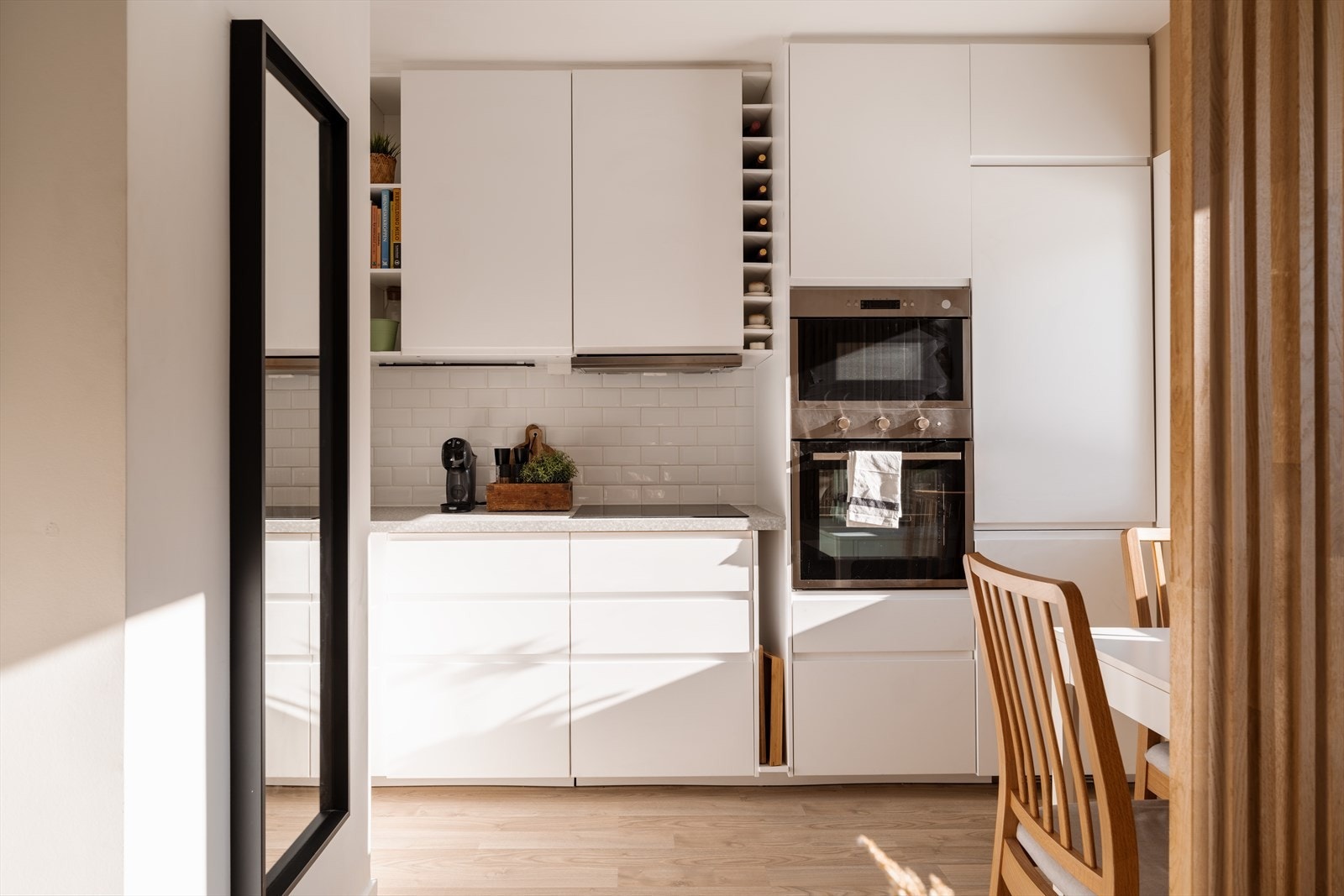 Hvit og moderne kjøkkeninnredning fra 2019 med glatte fronter og integrerte hvitevarer. Galleribilde