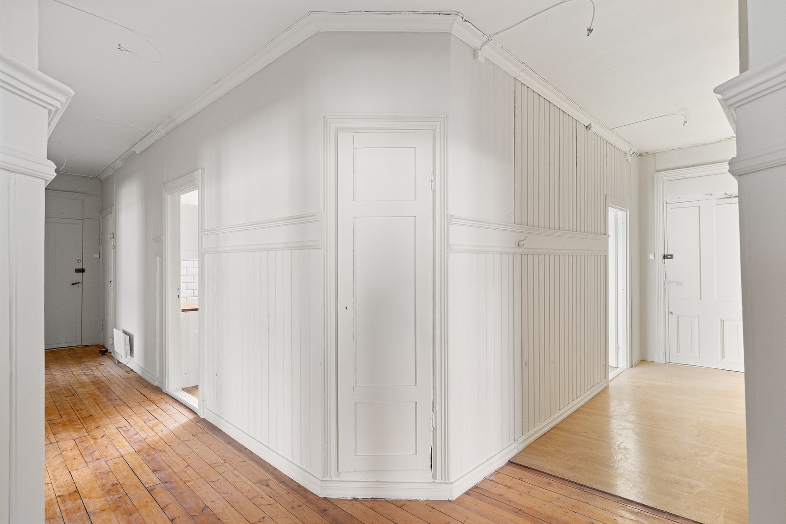 Lys og romslig entré med med to inngangsdører, én fra hvert trappeløp. Galleribilde