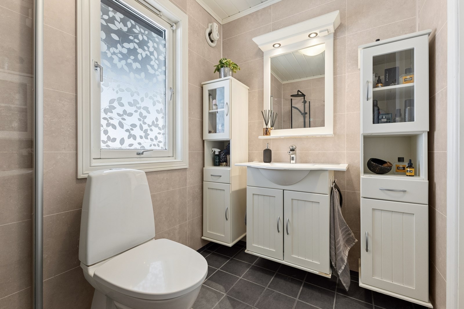 Innredningen inkluderer servant med underskap, klosett og et praktisk dusjhjørne. Et godt sted å starte dagen! Galleribilde