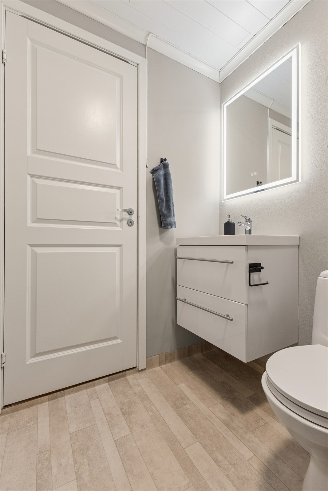 Rommet er innredet med servant med underskap, klosett og dusjkabinett. En elektrisk vifte i himlingen sørger for ventilasjon. Galleribilde