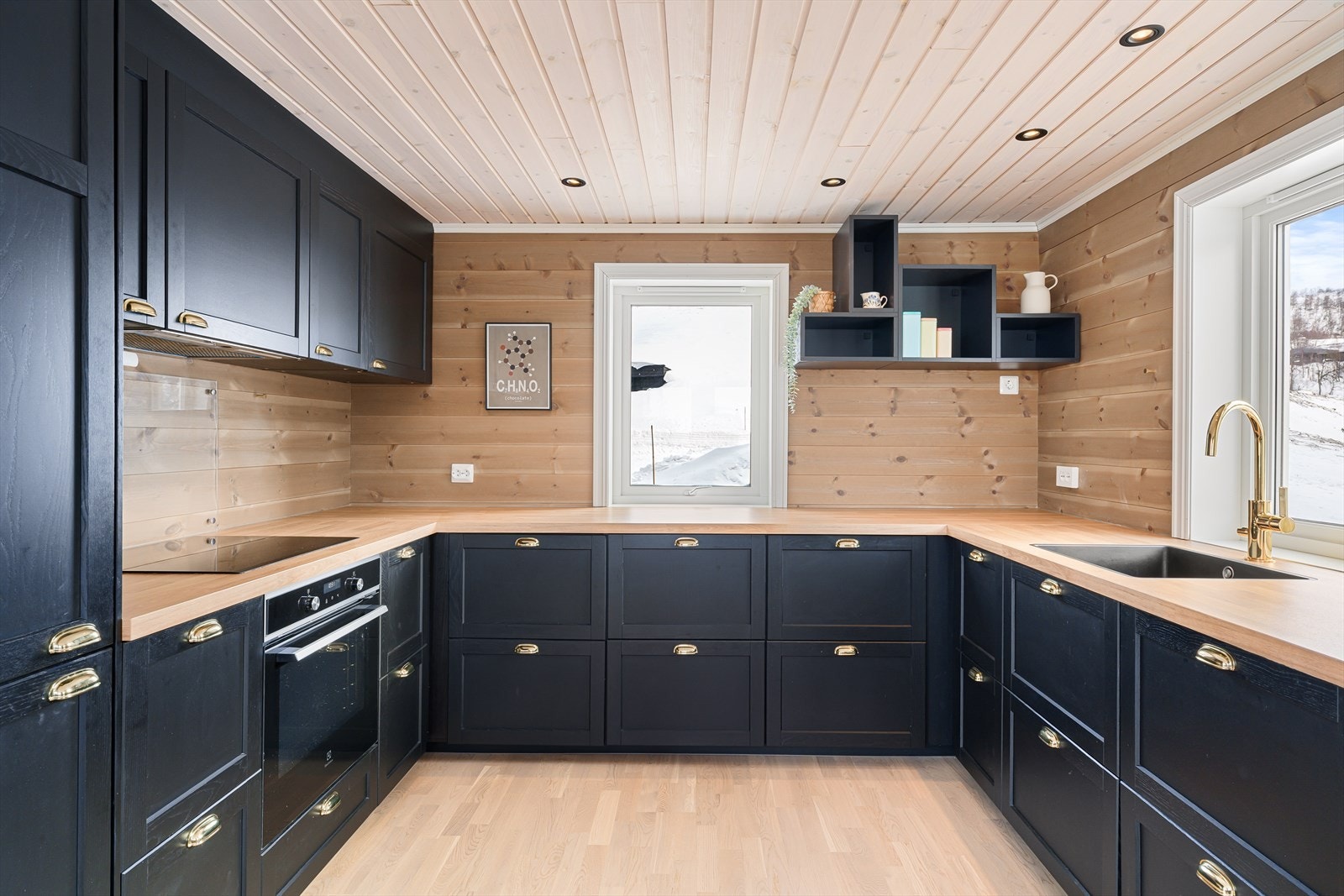 Kjøkkenet er svart og har integrerte hvitevarer. Galleribilde