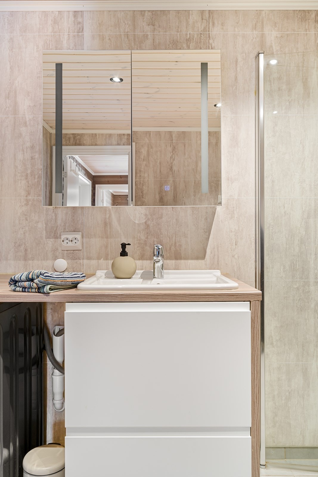 Våtromsplater på veggene og panel med spotter i tak. Galleribilde