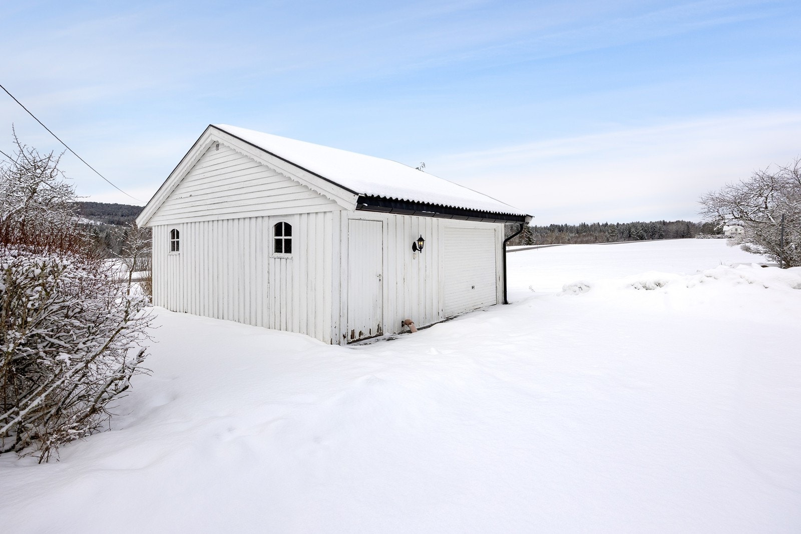 Det er parkering i en frittliggende garasje og på en gruslagt gårdsplass. Galleribilde