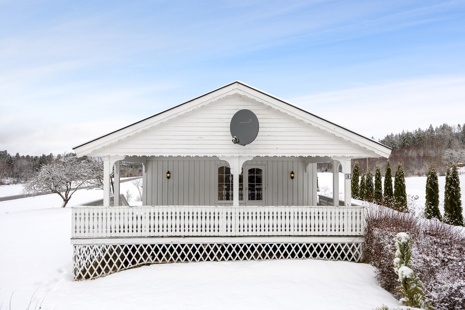 Verandaen har dekke og rekkverk i tre, og det er montert stemningsfull utebelysning på husveggen. Galleribilde