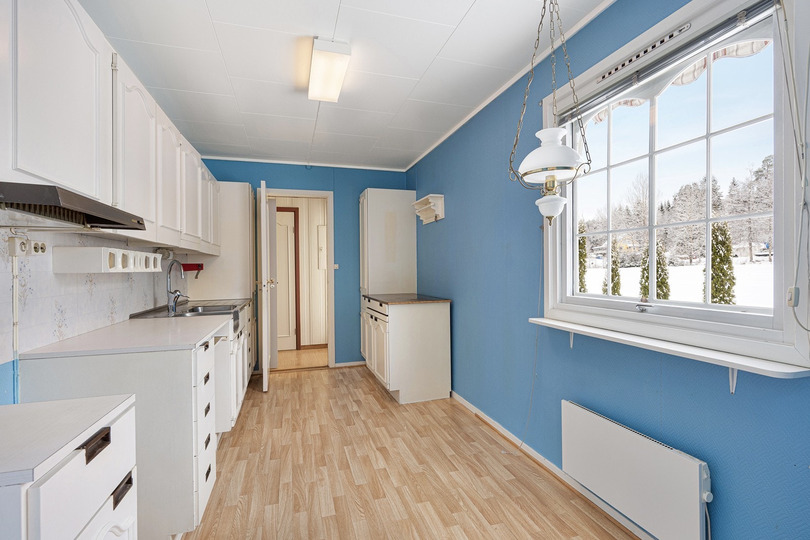 Kjøkkenet er av eldre dato, og har et klassisk design med god skap- og benkeplass. Innredningen har hvite, profilerte fronter, lys laminatbenkeplate og benkebeslag i stål med oppvaskkum og utslagsvask. Galleribilde