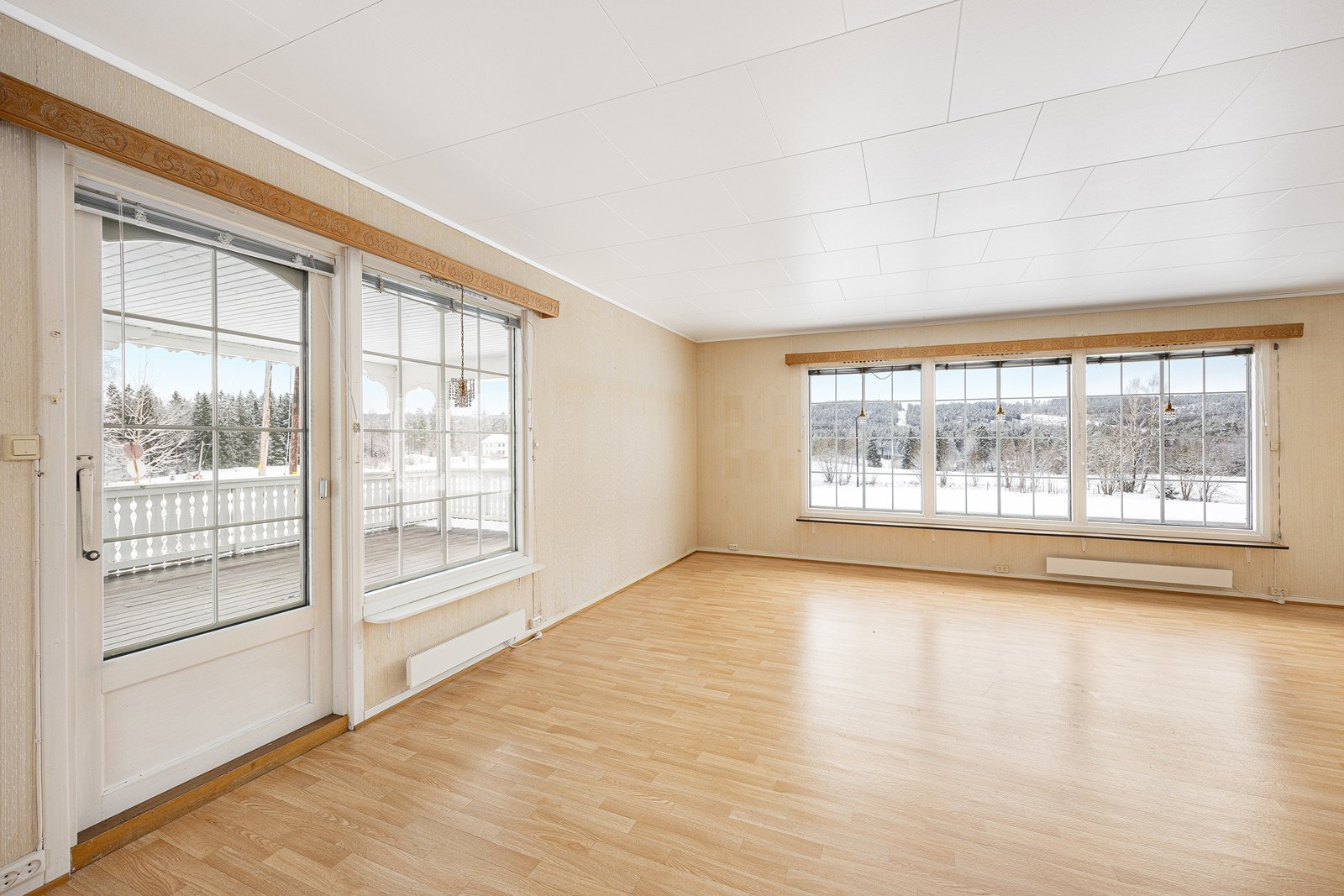 Dagslyset strømmer inn via store sprossevinduer i tre himmelretninger, og stuen kan stolt skilte med langstrakt, naturskjønn utsikt. Galleribilde