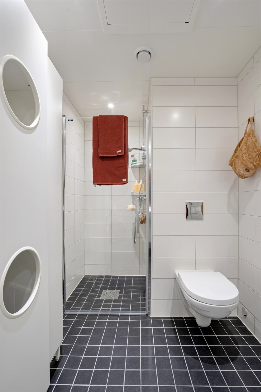 Her er det dusjløsning med glassvegger, servant med innredning, vegghengt toalett og opplegg for vaskemaskin - praktisk og funksjonelt for hverdagsbruk. Galleribilde