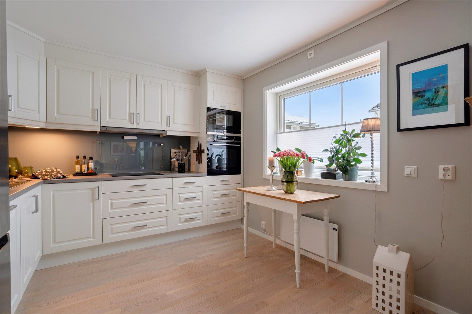 Kjøkkeninnredningen har profilerte fronter og en benkeplate i heltre. Det er også plass til et lite kjøkkenbord ved vinduet. Galleribilde