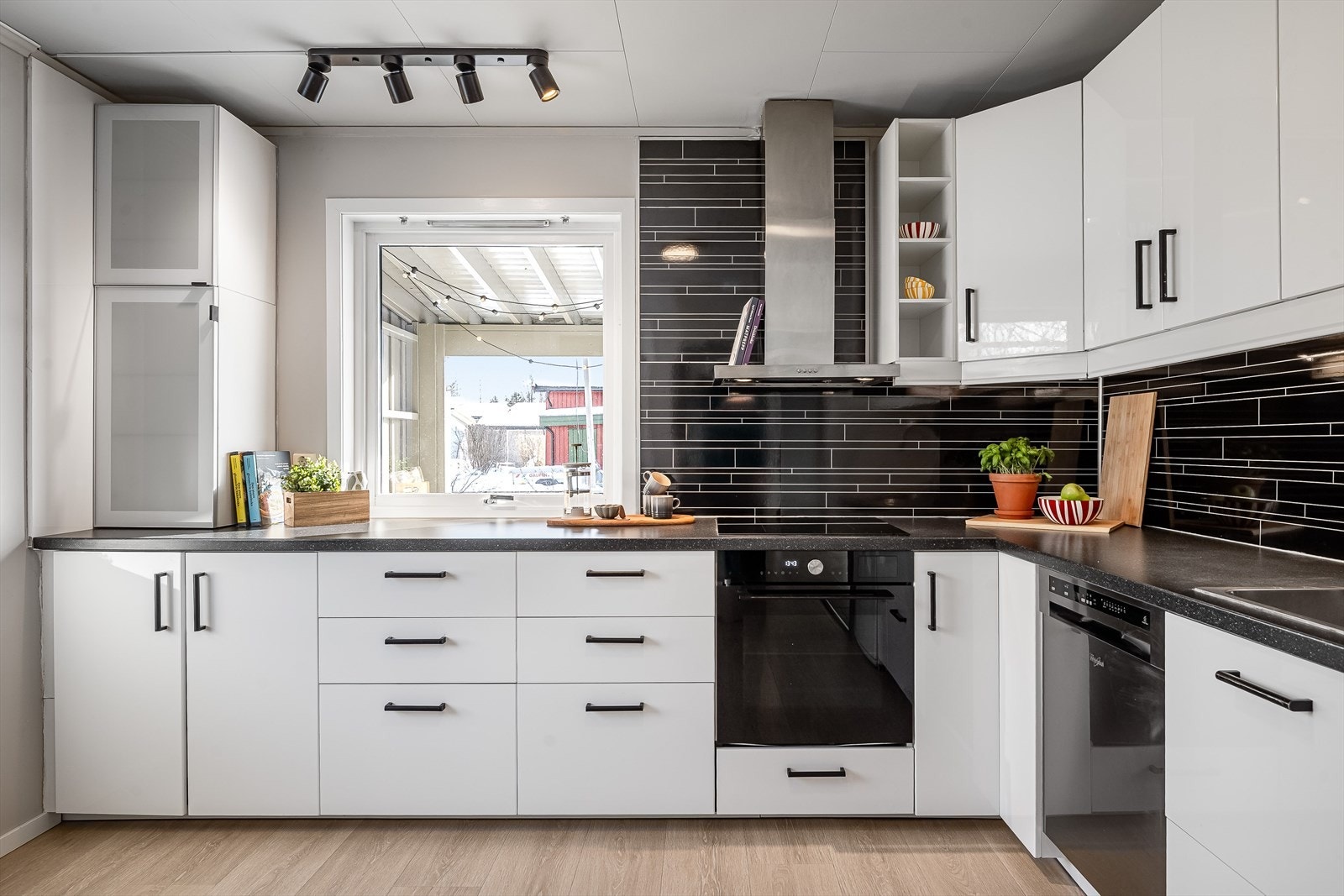 Lys og moderne kjøkkeninnredning med god skap- og benkeplass. Innredningen har hvite glatte fronter og laminert benkeplate med nedfelt oppvaskkum. Galleribilde