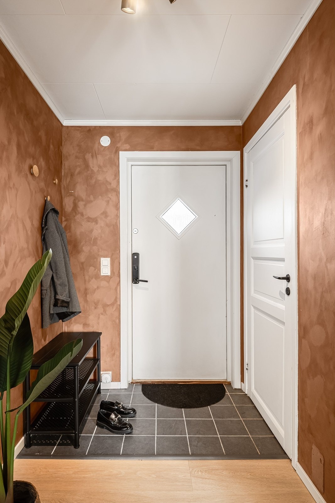 Når du entrer boligen kommer du inn i en flislagt entré med plass til sko og oppheng av yttertøy. Praktisk med kodelås montert på ytterdøren. Galleribilde