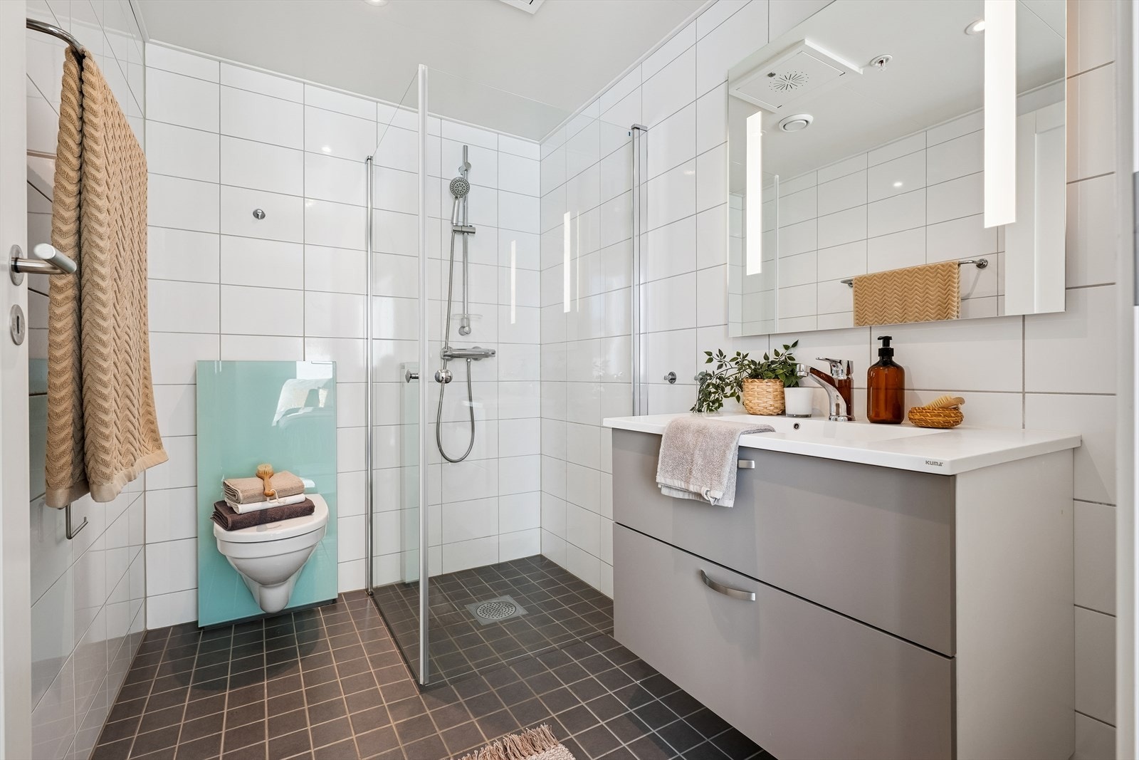 Leiligheten har to delikate bad. Dette badet har vegghengt toalett og dusjhjørne. Galleribilde