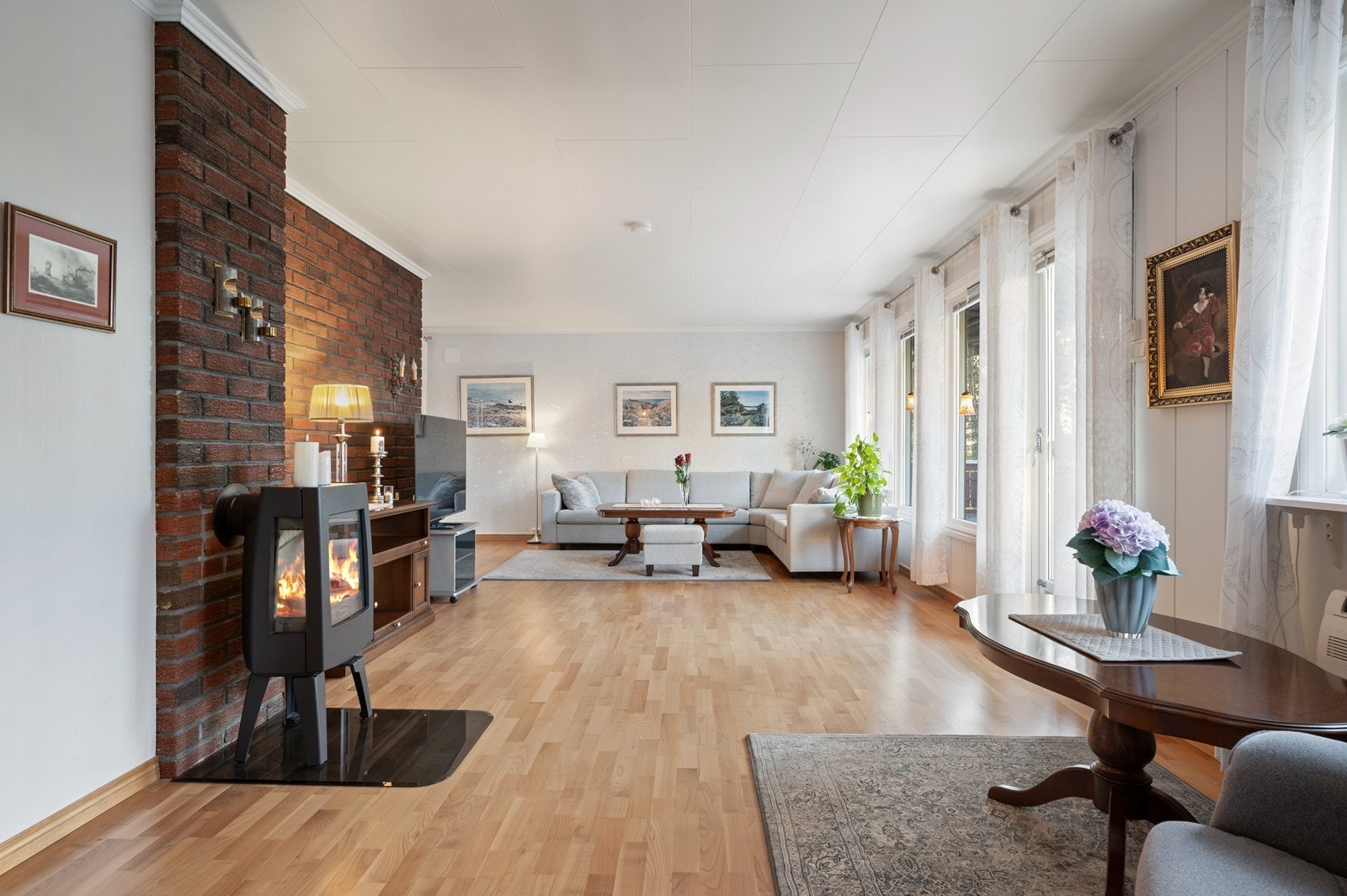 En moderne vedovn og en eksponert teglsteinsvegg gir rommet særpreg og varme. Galleribilde