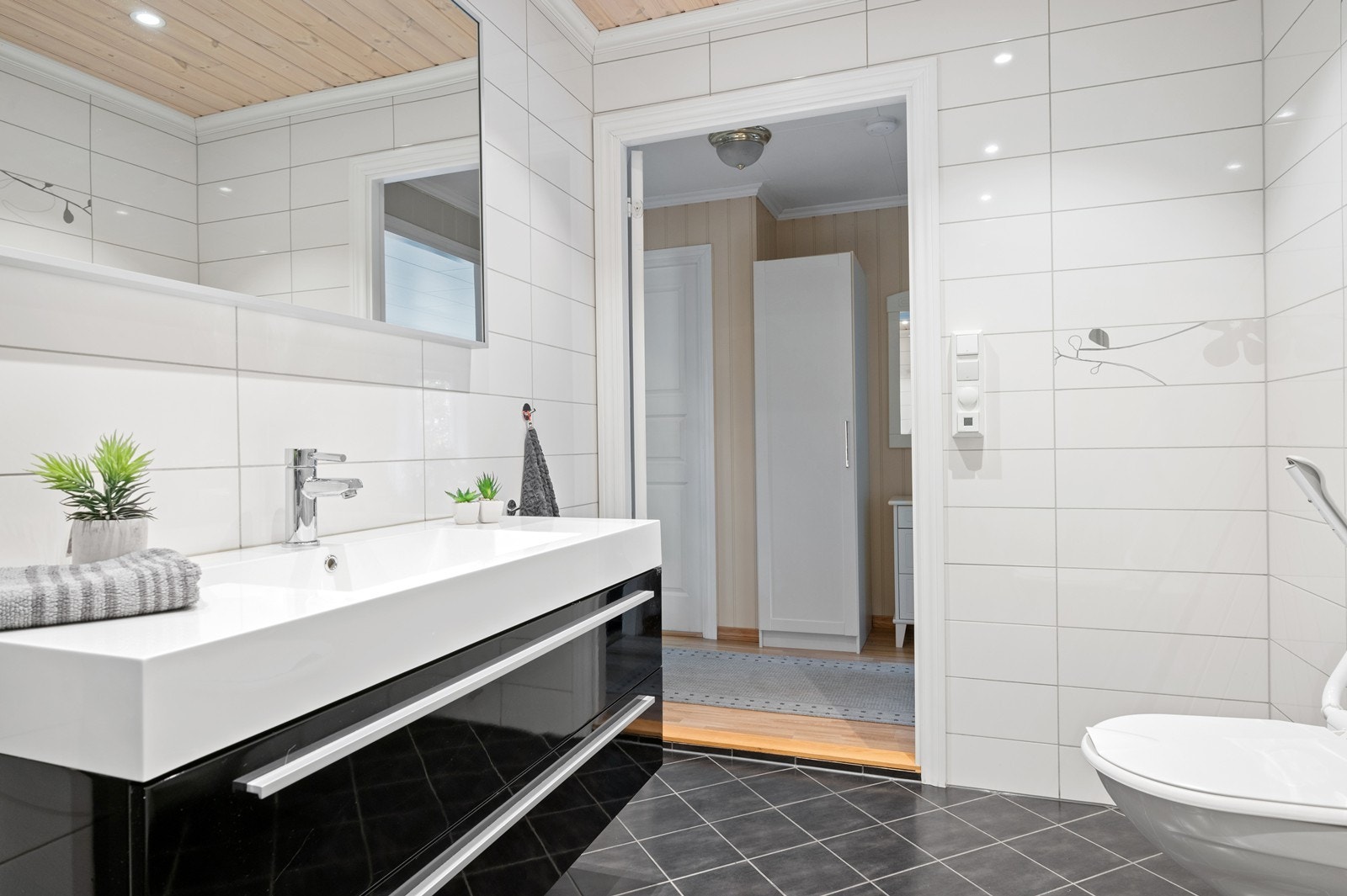 Moderne baderomsinnredning med heldekkende servant og skuffer med god oppbevaringsplass. I tillegg er det montert høyskap i samme utførelse, for ytterligere lagringsplass. Galleribilde