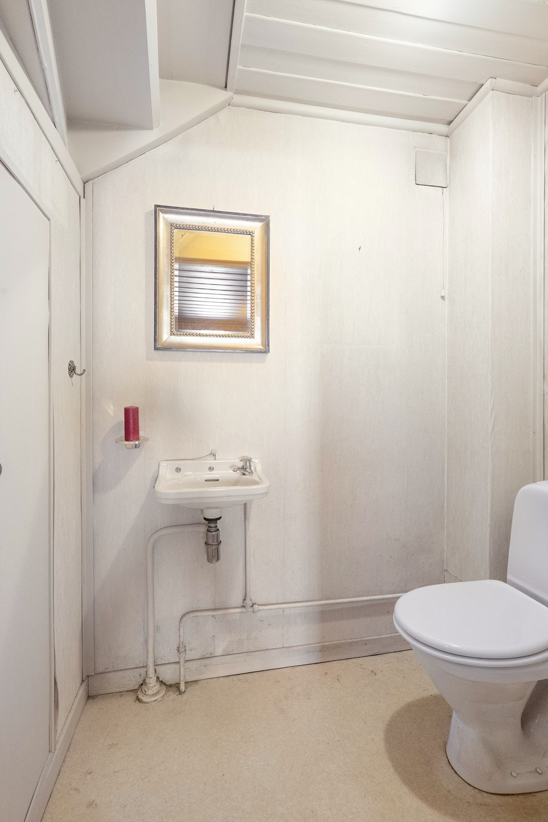 Inntil gangen er det etablert toalettrom med belegg på gulvet og tapet på vegger. Her er det toalett og enkel vaskeservant. Galleribilde