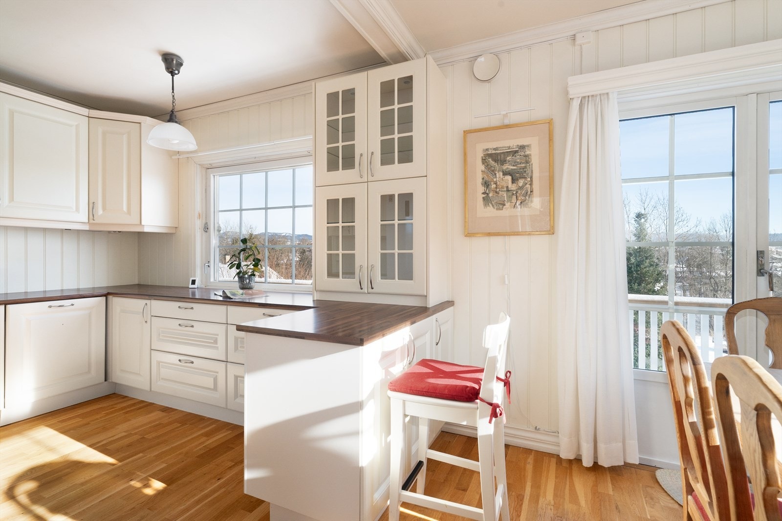 Som et naturlig skille mot spiseplassen er det en kjøkkenhalvøy med et koselig glass-skap med plass til fin-servicet. Galleribilde