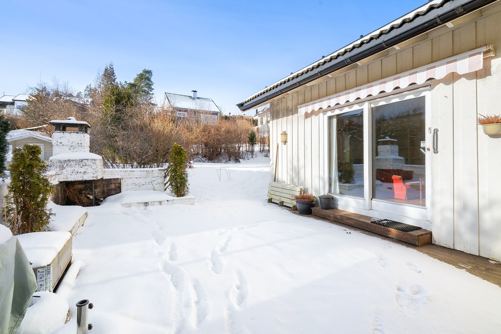 Her er det også murt opp en koselig utepeis med sittebenker på hver side. Over stuevinduet er det etablert markise for solskjerming. Galleribilde