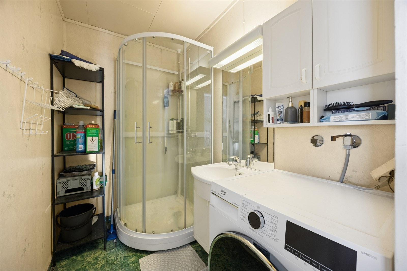 Badet er innredet med dusjkabinett, servantinnredning og opplegg for vaskemaskin. Galleribilde