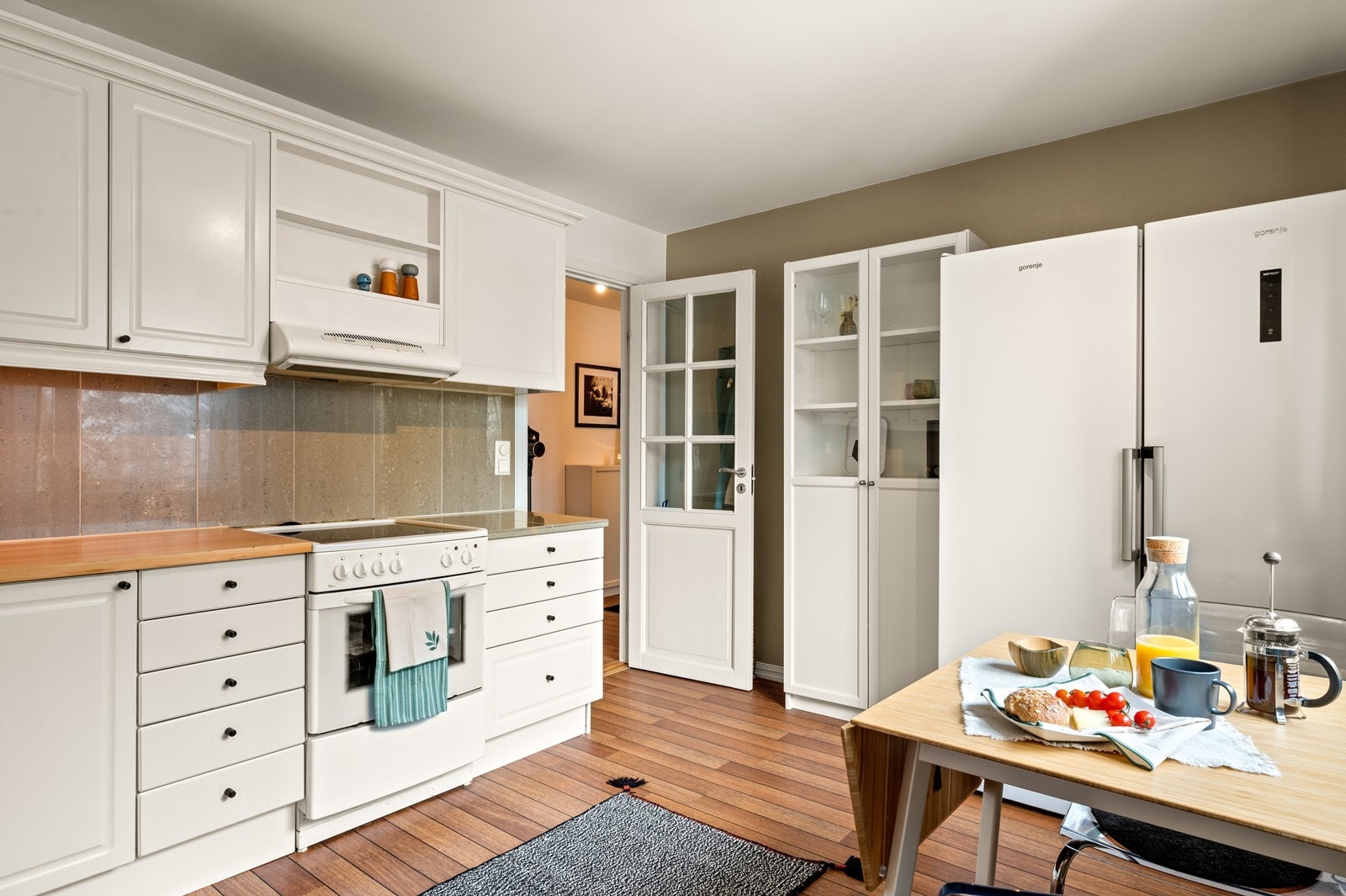 Rommet er utstyrt med frittstående komfyr, kjøl/fryseskap og oppvaskmaskin. Galleribilde