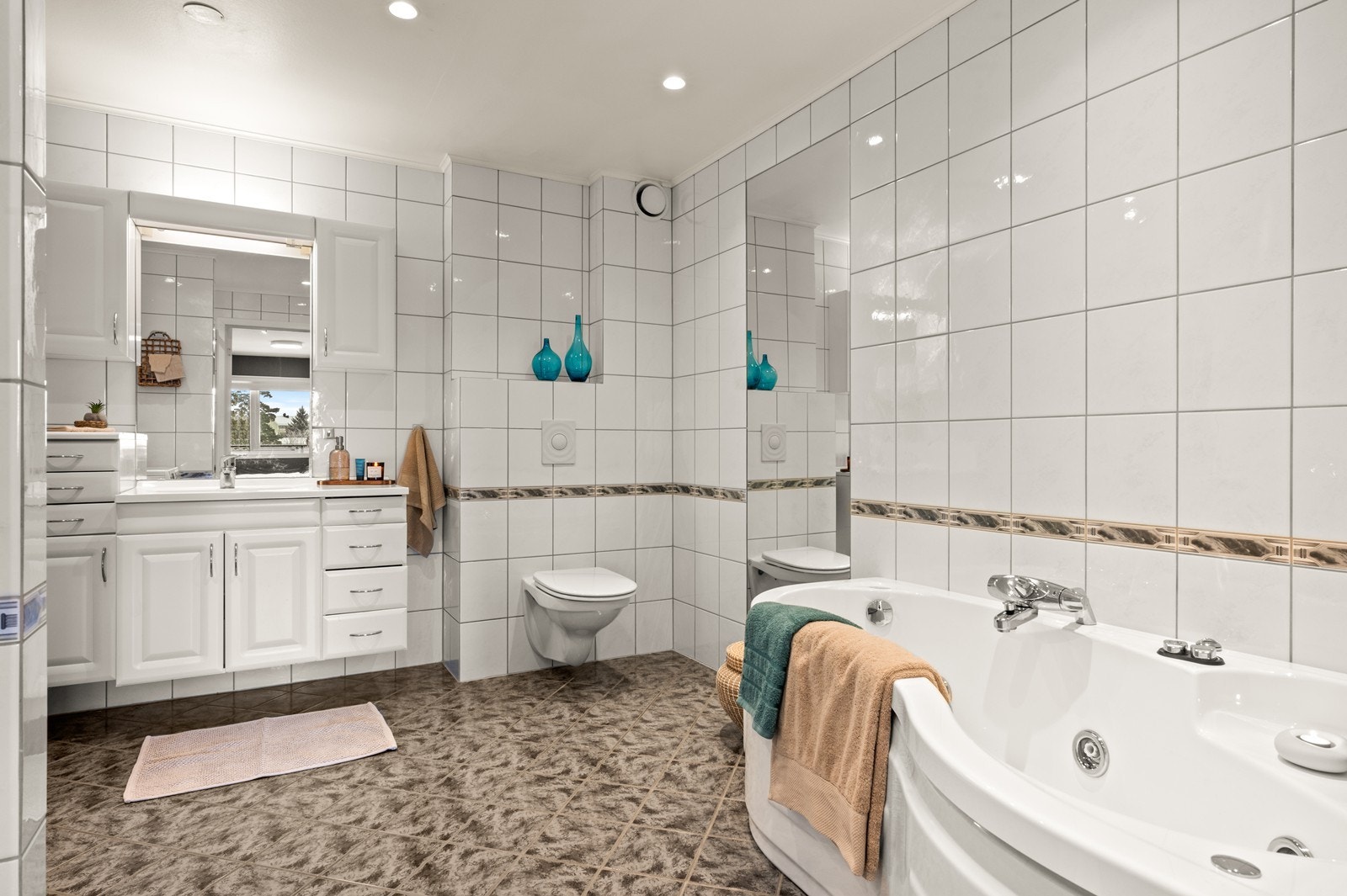 Det store, flislagte badet er utstyrt med både dusjnisje og et innbydende massasjebadekar. Galleribilde