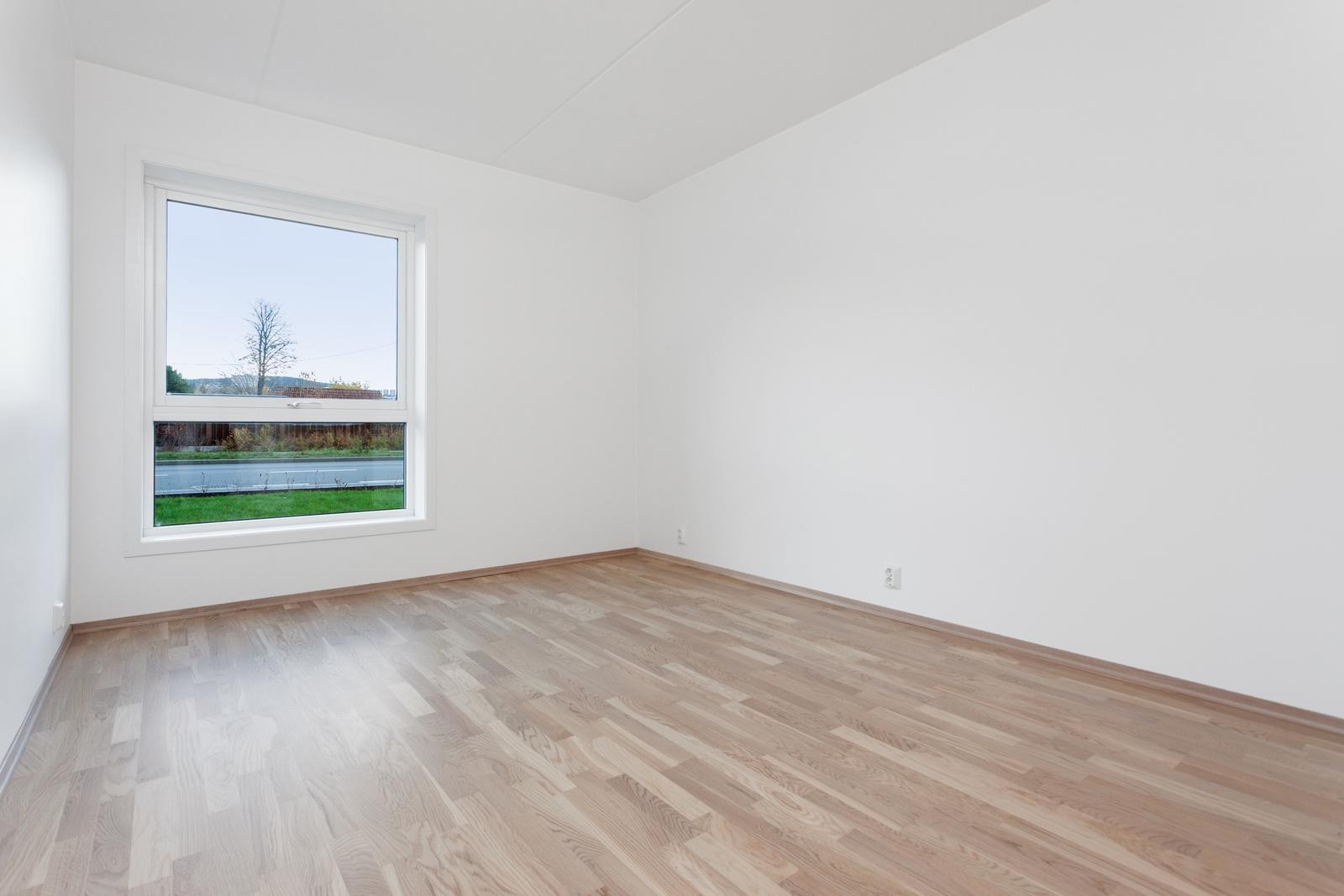 Ett av boligens to romslige soverom med god plass til dobbeltseng og inngang til innvendig bod. Galleribilde