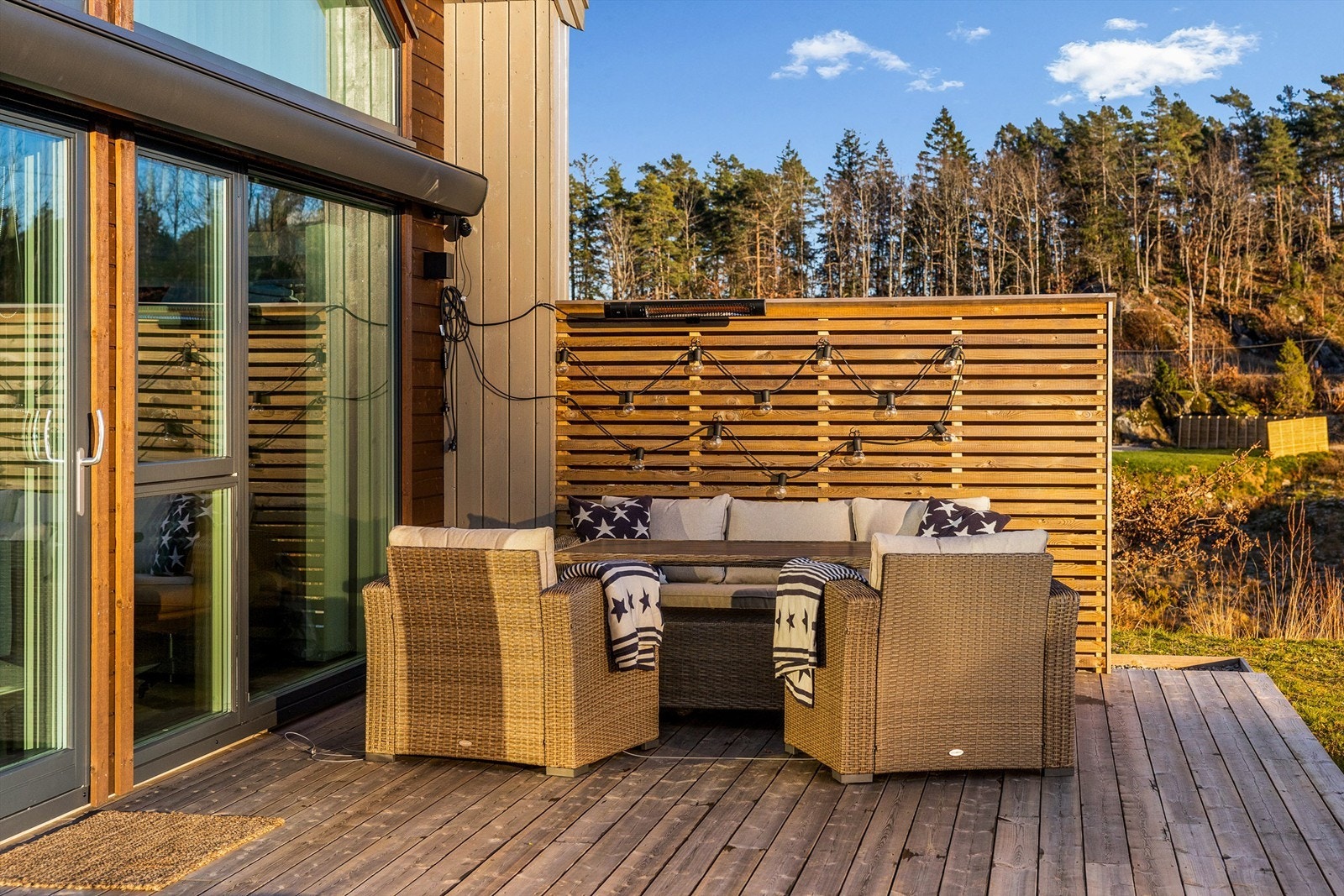 UTEPLASS MED EKSTRA DIMENSJON: I hjørnet utenfor stuen er det laget en skjermet uteplass. Den er møblert med lave lounge-sofaer. Den store markisen gir sitteplassen en ekstra dimensjon. Galleribilde