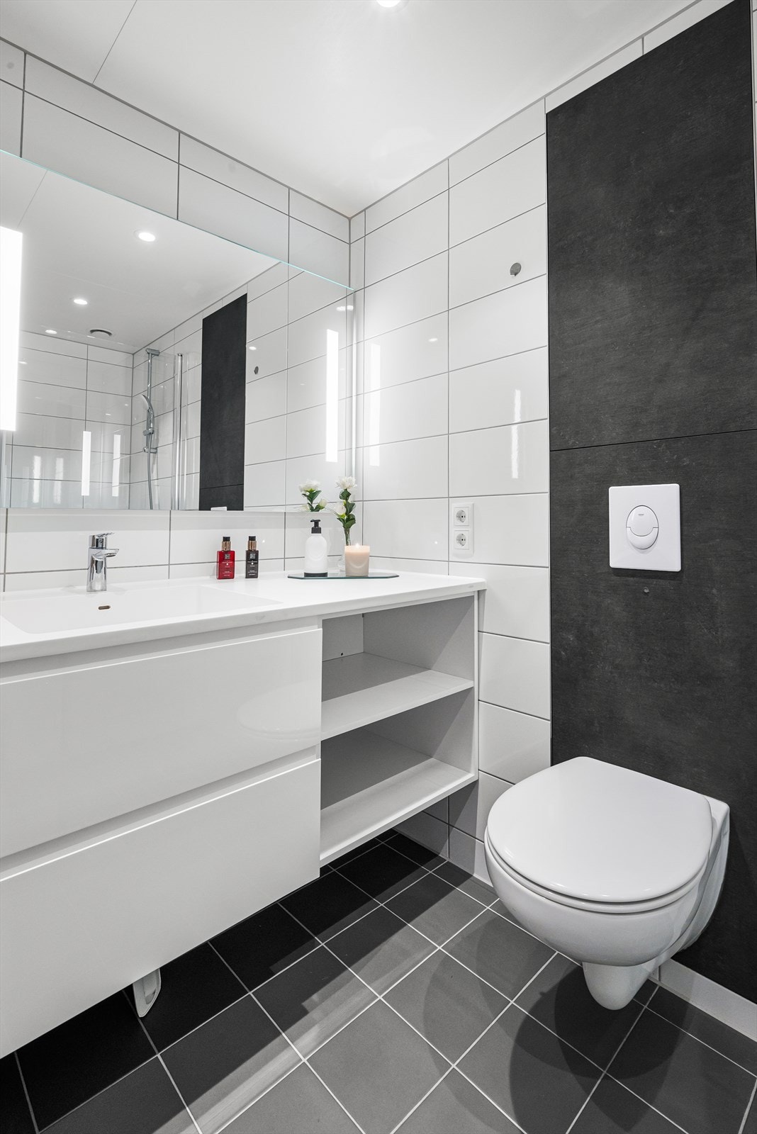 Badet byr på vegghengt wc, dusjhjørne med sammenslåbare dusjvegger og spotter i tak. Galleribilde