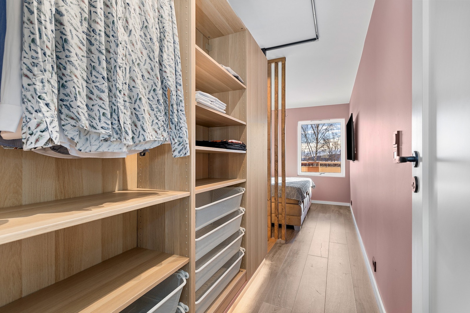 Den vinklede garderoben har god oppbevaringsplass i åpne hyller, skuffeseksjoner og klesoppheng Galleribilde