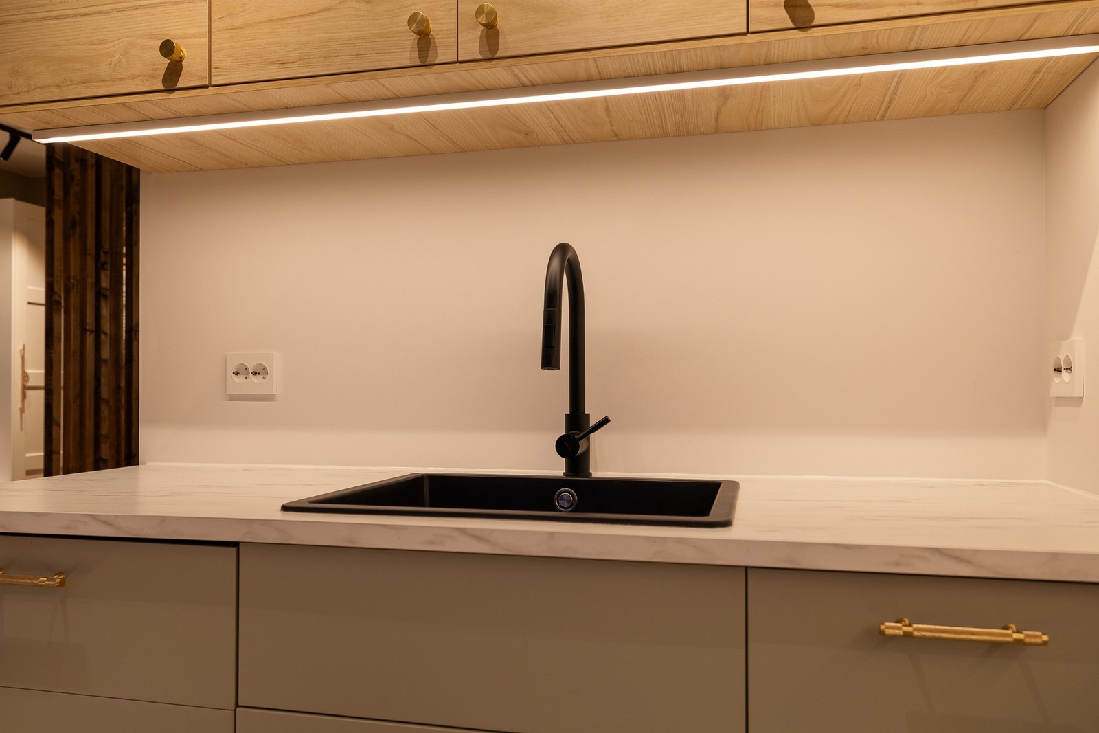 Kjøkkenet har benkeplater i laminat og en nedfelt vask av sort kompositt Galleribilde