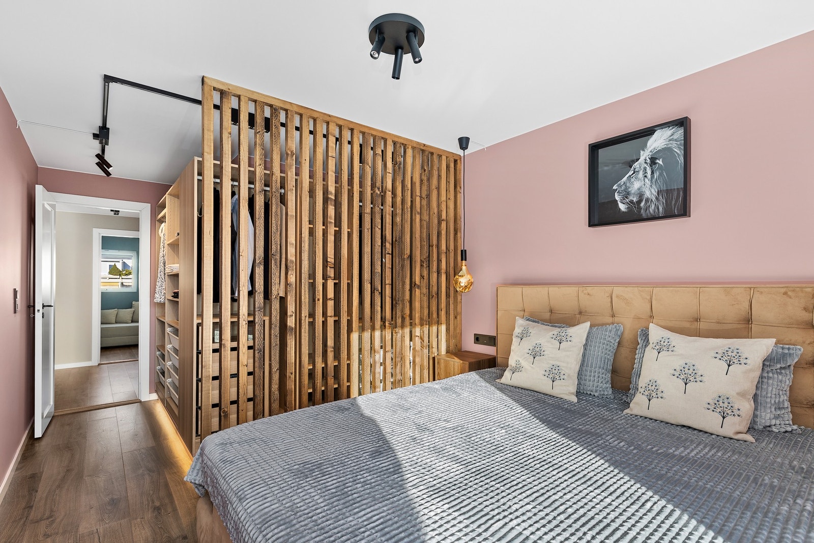 Garderoben er pent avgrenset med skillevegg i trespiler mot seng Galleribilde
