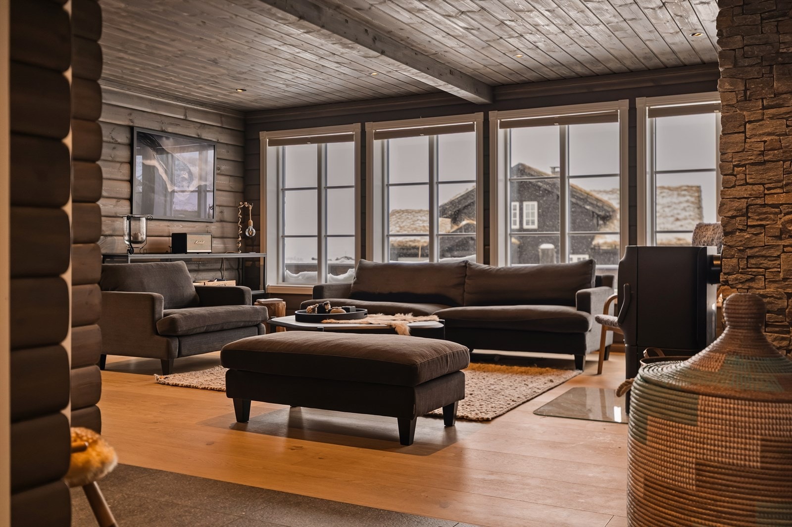 Stua fremstår som hyttas naturlige samlingspunkt, med nyere vedovn og steinlagt pipe som skaper en lun atmosfære. Galleribilde