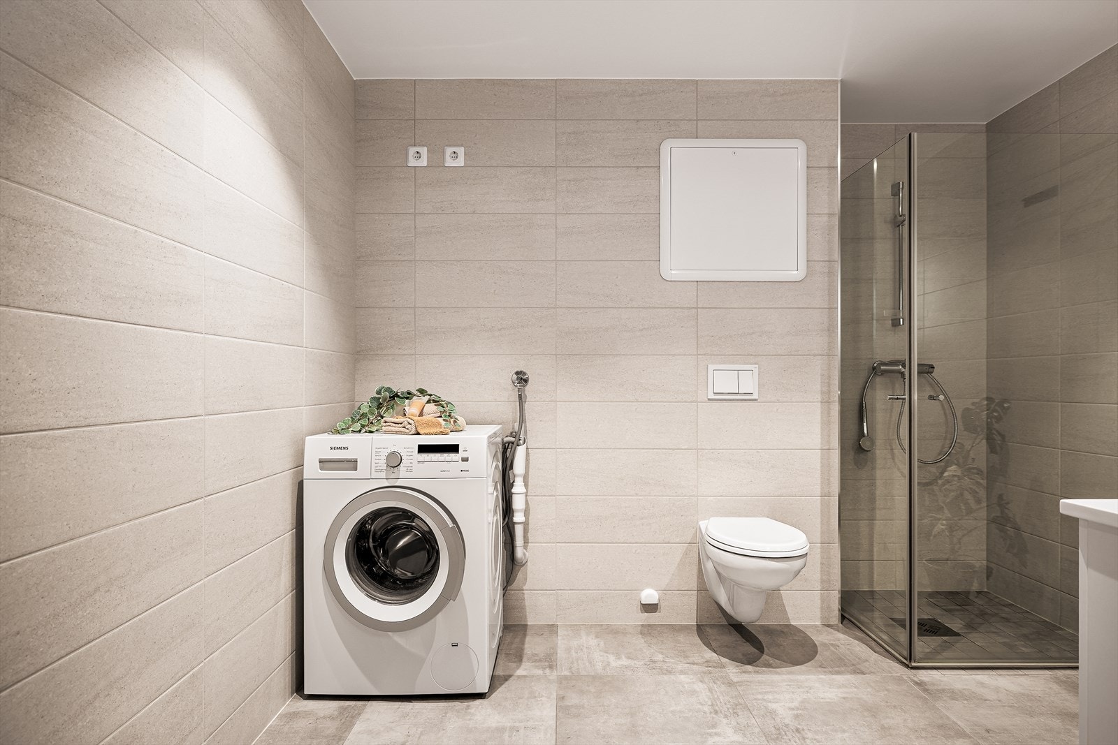 Rommets størrelse gir god plass til vaskemaskin, og man kan fint ha tørketrommel oppå denne. Oppsummert et lekkert baderom som vil gi deg en god start på dagen! Galleribilde