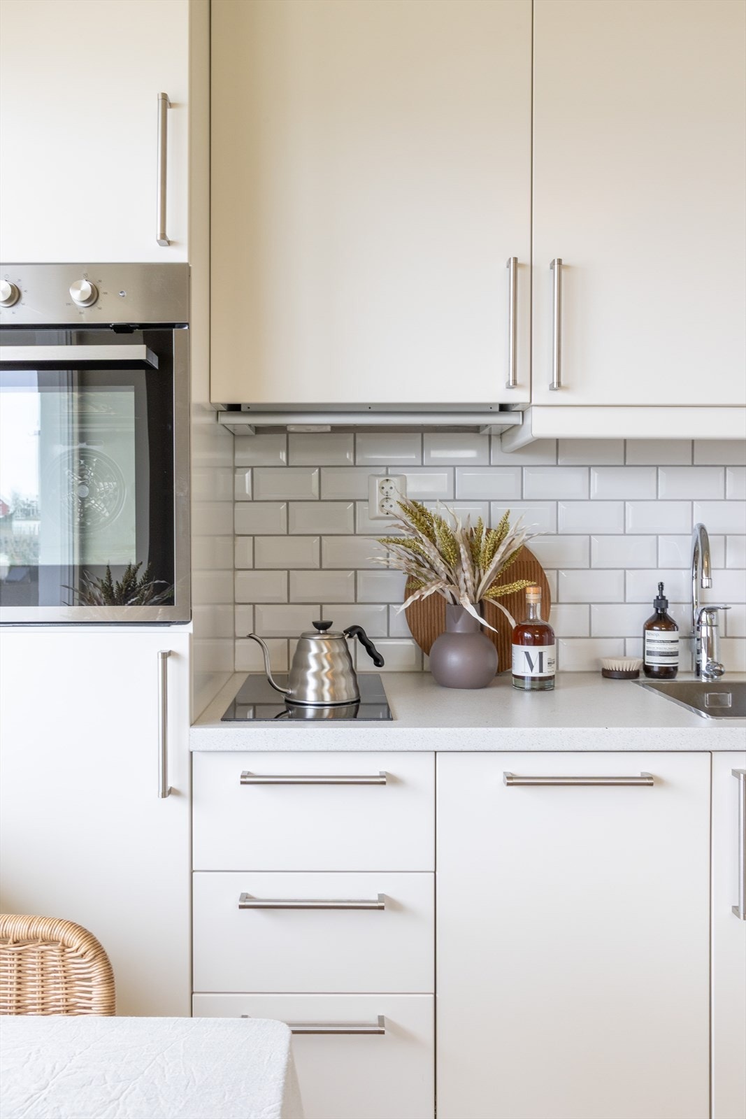 Kjøkkeninnredningen fra IKEA strekker seg langs den ene veggen og har en moderne fremtoning med hvite, glatte fronter og benkeplate i laminat. Galleribilde