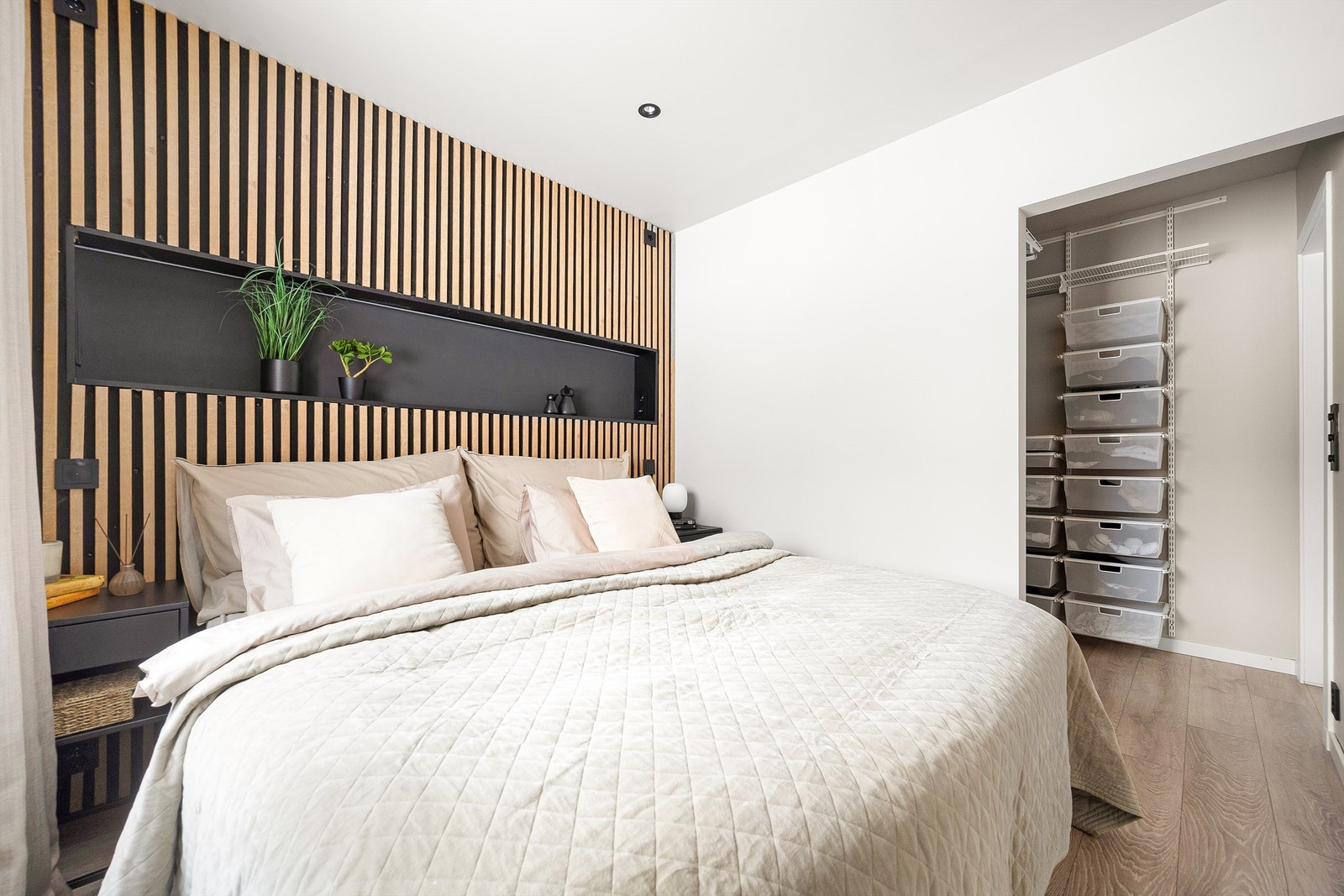 Hovedsoverommet har en stilfull fondvegg med spilepanel og en praktisk, åpen garderobeløsning. Galleribilde