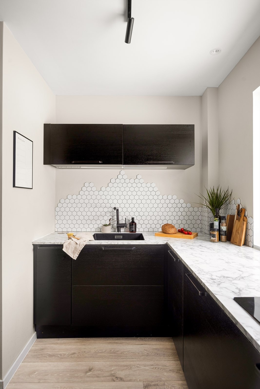 Planlimt oppvaskkum i kompositt og flislagt vegg mellom benk og overskap. Galleribilde