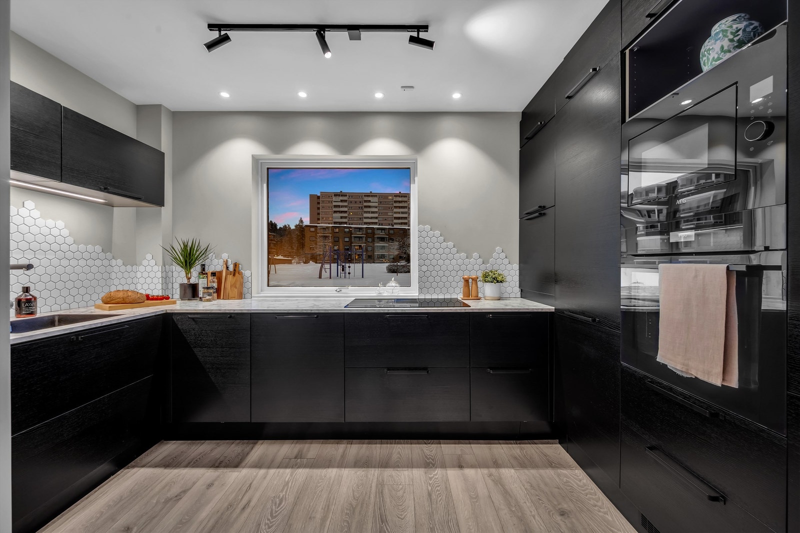 Moderne kjøkken fra Epoq (2021) med slette, mørke fronter og laminat benkeplate. Galleribilde