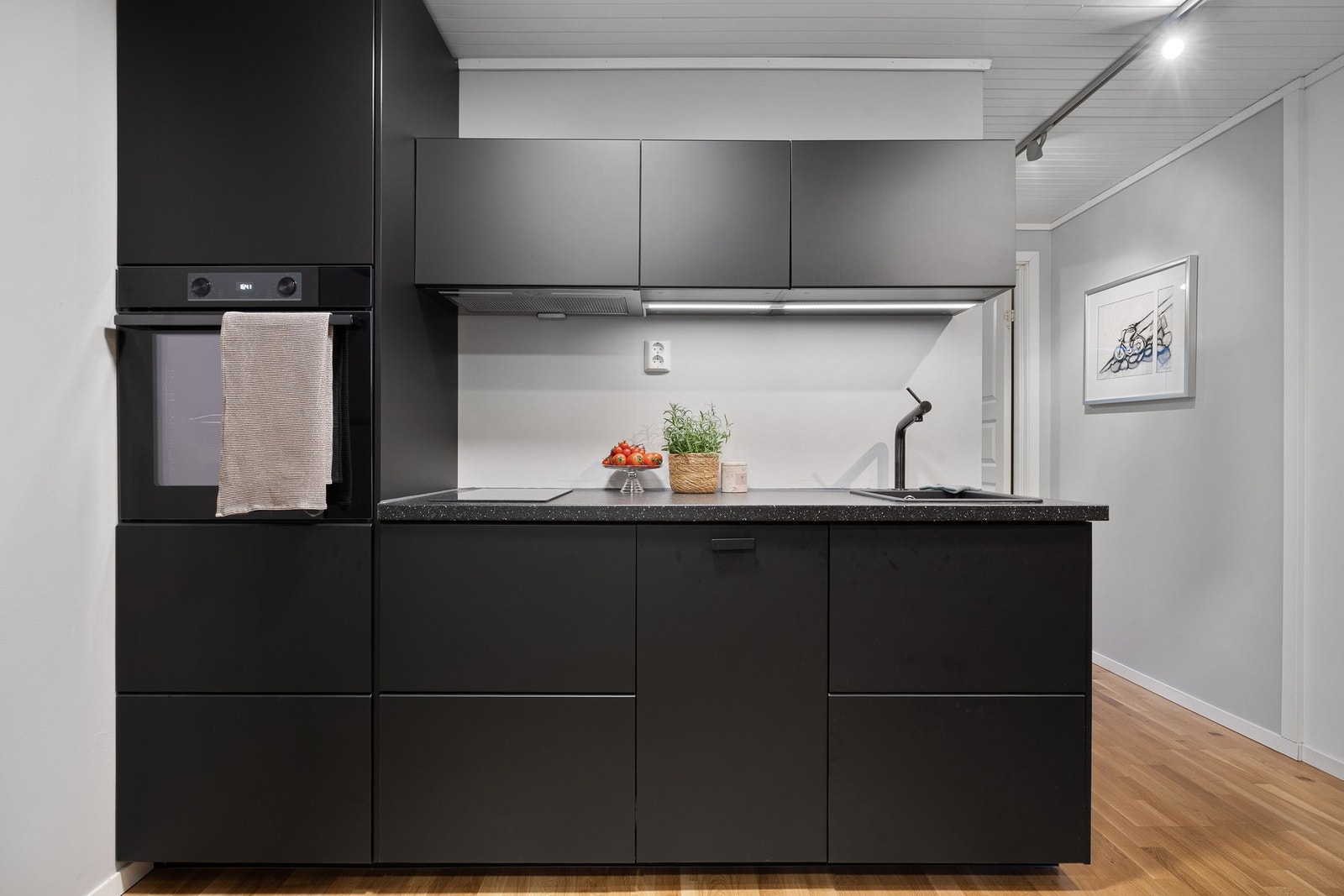 Kjøkkeninnredningen med laminert utførelse med glatte fronter og laminat benkeplate. Galleribilde