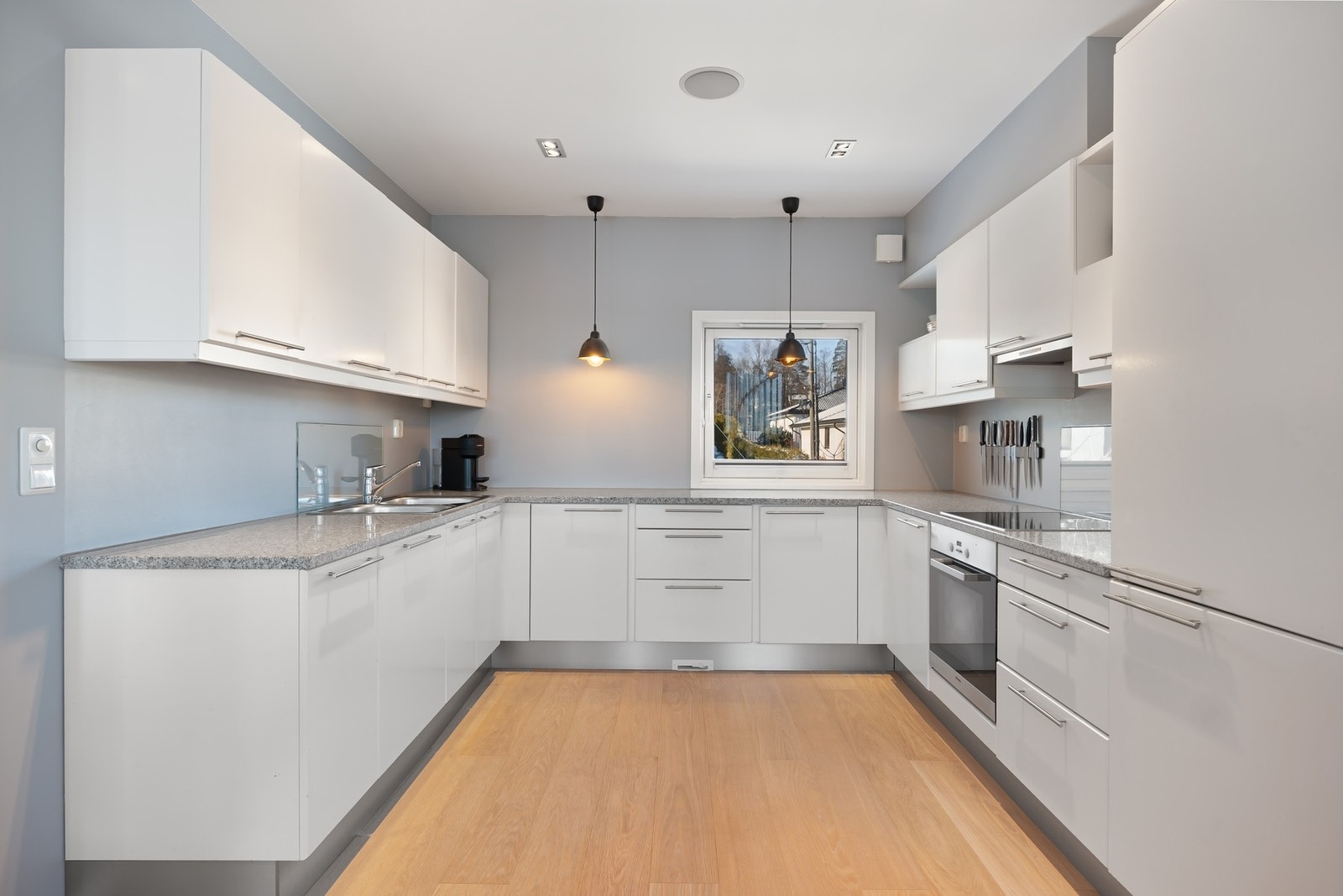 Nyere moderne innredning med glatte malte fronter og overskap. Benkeplater av granittsten med nedfelt vaskekum og platetopp. Galleribilde