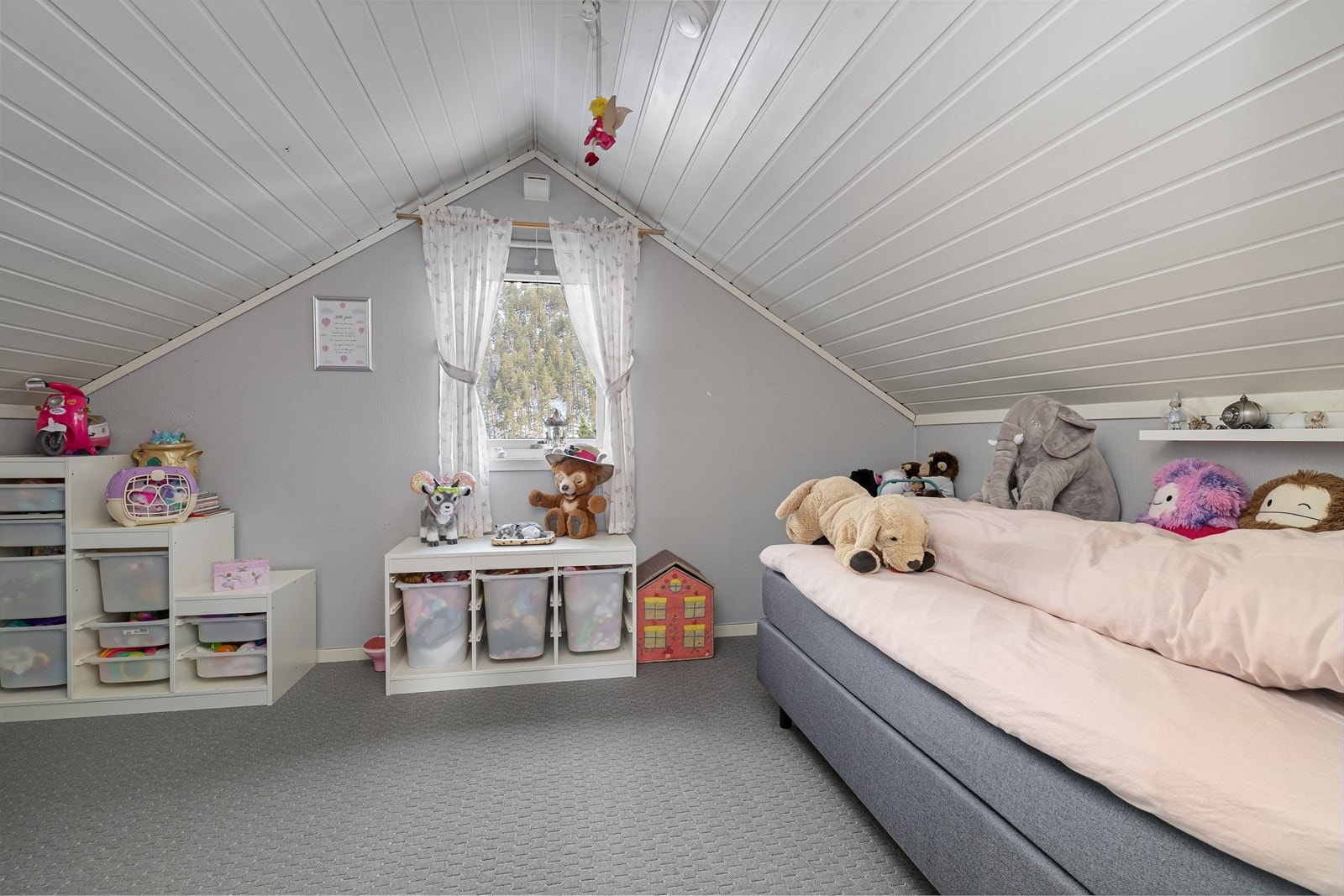 Lyst og romslig rom med teppe på gulv, malt tapet på vegg og malt panel i himling. Galleribilde