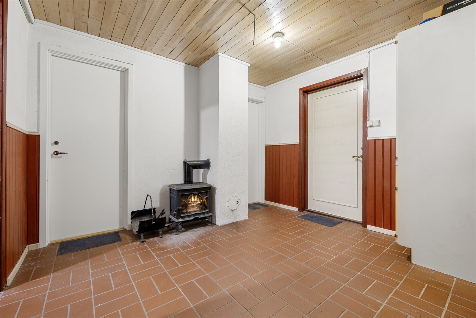 Den separate inngangen i sokkelen leder inn til en romslig hall med vedovn. Galleribilde