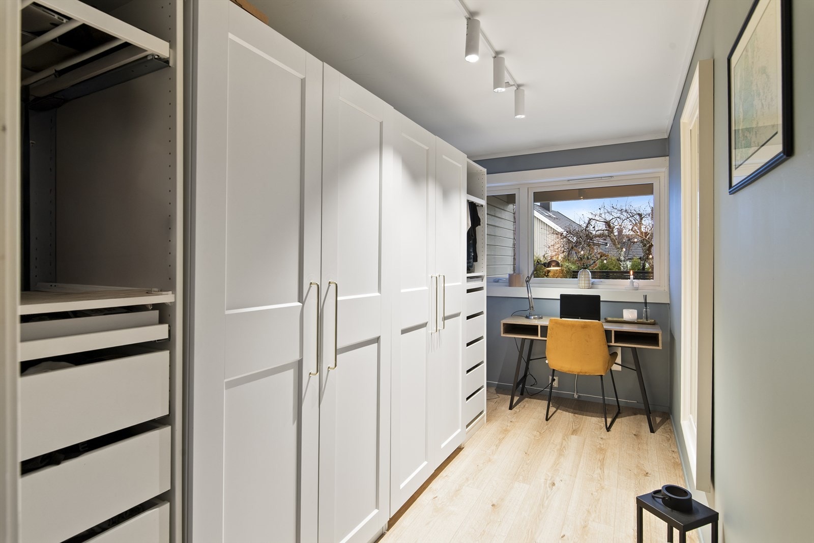 Innbydende garderoberom med rikelig plass til klær. Her er det også plass til kontorkrok. Galleribilde