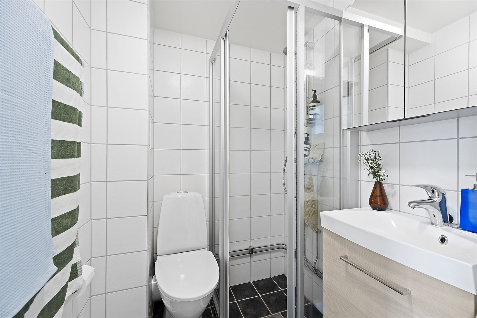 Badet ble pusset opp i regi av borettslaget og har behagelig gulvvarme. Badet er utstyrt med dusjhjørne med svingbare glassdører Galleribilde