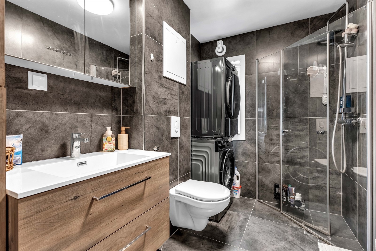 Lekkert baderom med opplegg for vaskemaskin og tørketrommel tilhørende hybeldel i 1. etasje. Galleribilde