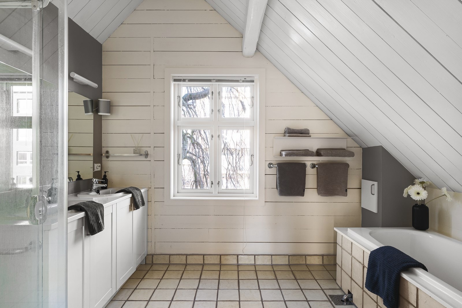 Flislagt baderom i andre etasje. Her er det også gode oppbevaringsmuligheter og plass til nødvendige baderominnredninger. Praktisk med skittentøysjakt. Galleribilde
