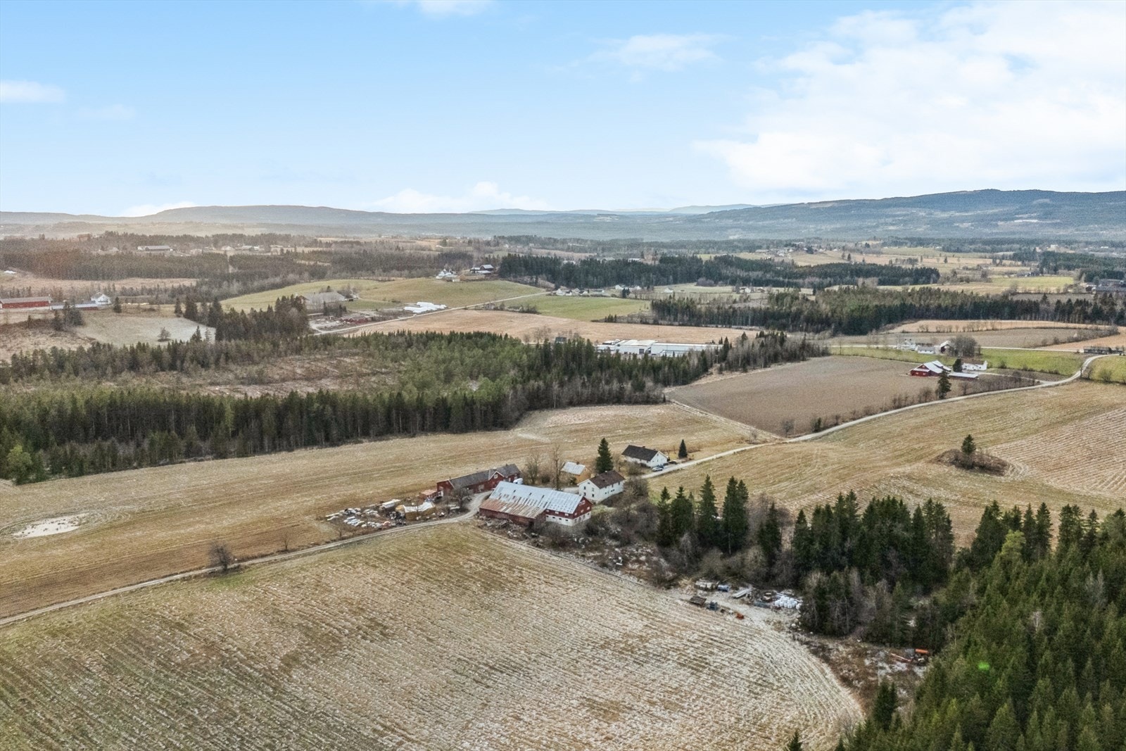 Omkringliggende landskap med gårdsbebyggelsen i forgrunnen, og mot sør-vest Galleribilde