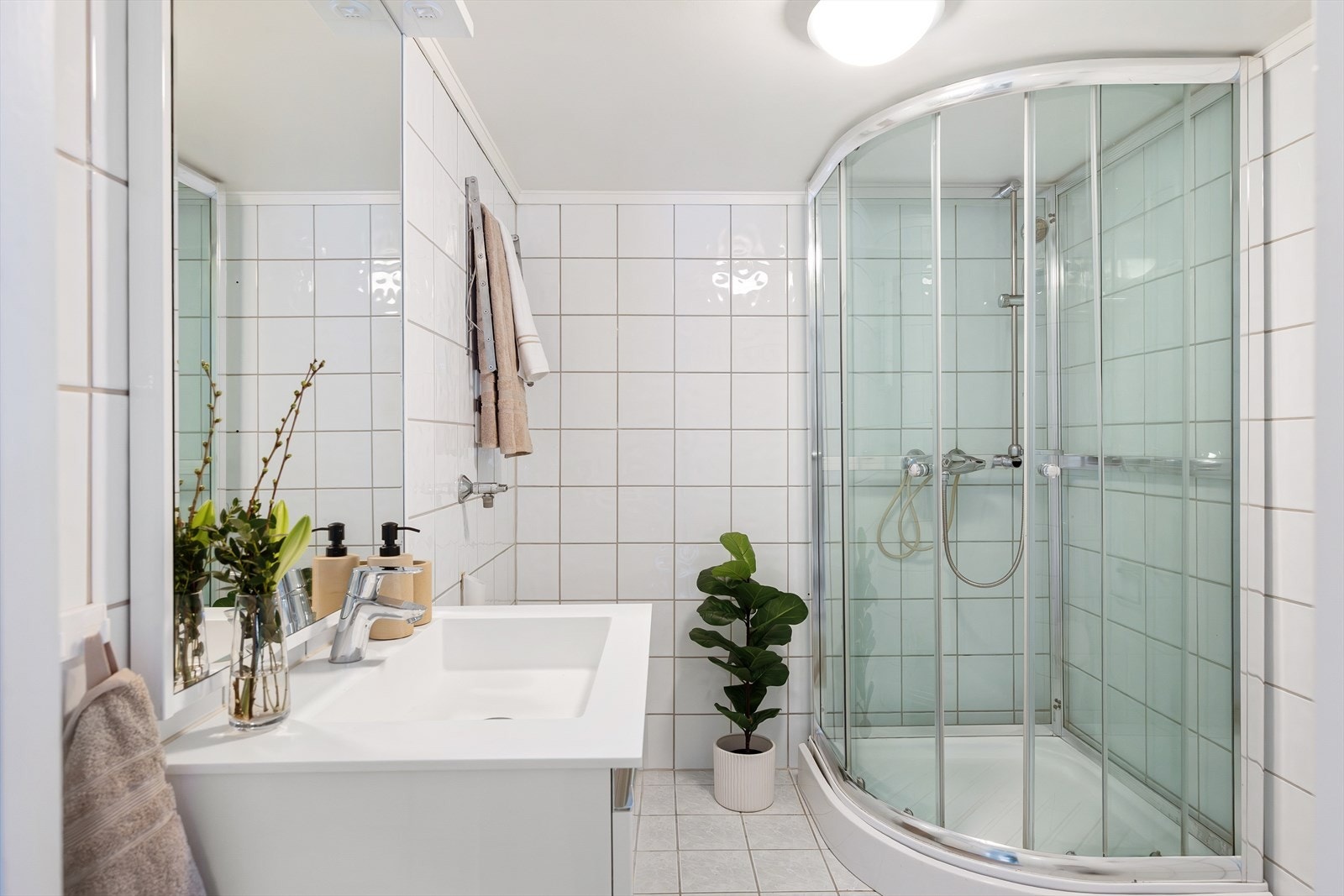 Eldre bad med reflektorovn. Badet er utstyrt med mekanisk avtrekk, opplegg for vaskemaskin, dusjkabinett, wc og servantskap med ettgreps blandebatteri fra Hansgrohe. Galleribilde