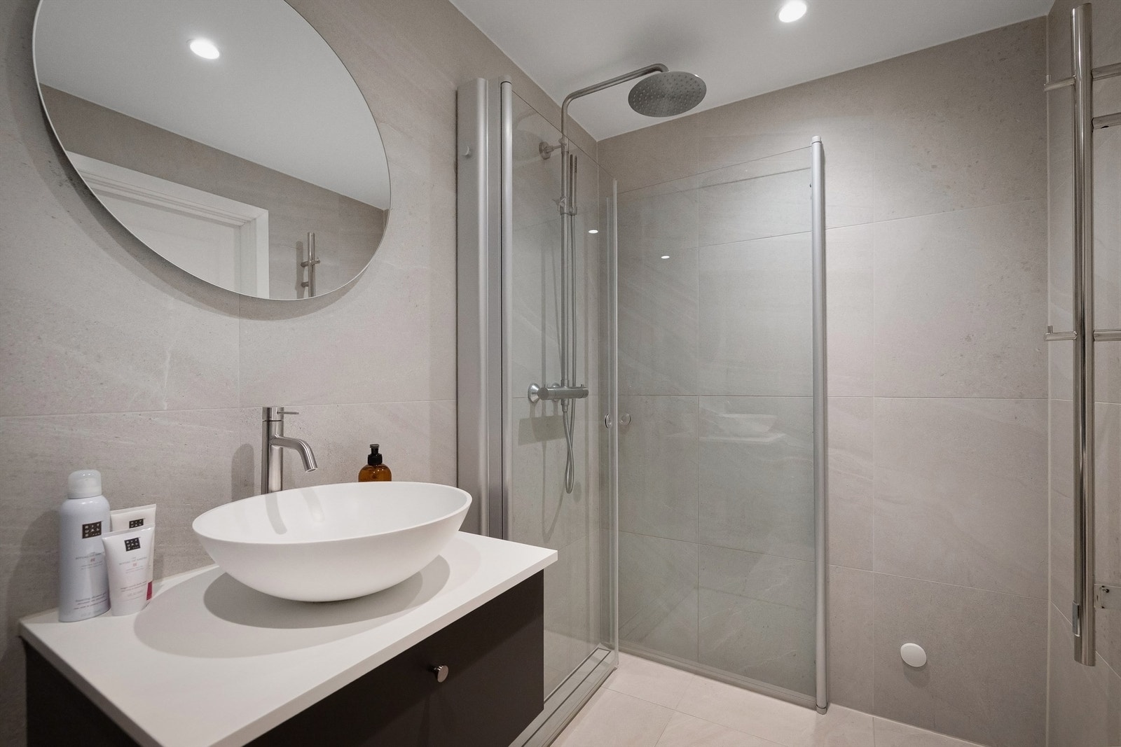 Badet inneholder servant med ett-greps blandebatteri, ovenpåliggende vask og speil, samt dusjhjørne med innfellbare dusjdører. Badet har opplegg for vaskemaskin. Galleribilde