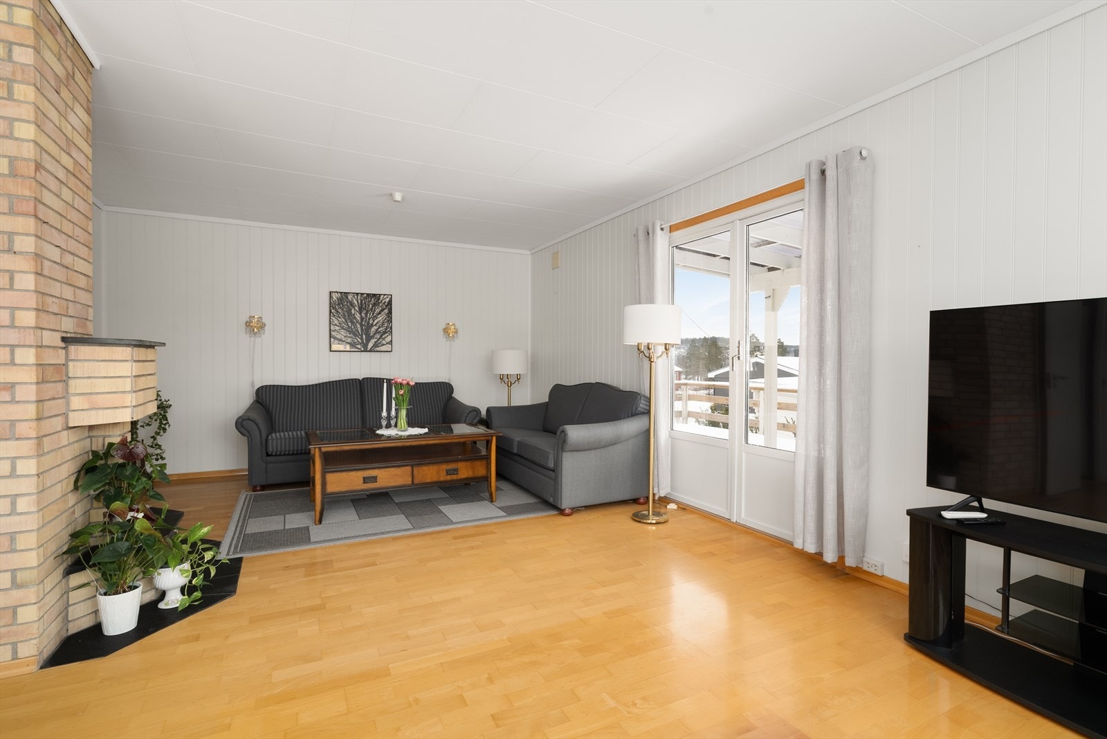 Stua har parkettgulv og malt panel på veggoverflatene. Galleribilde